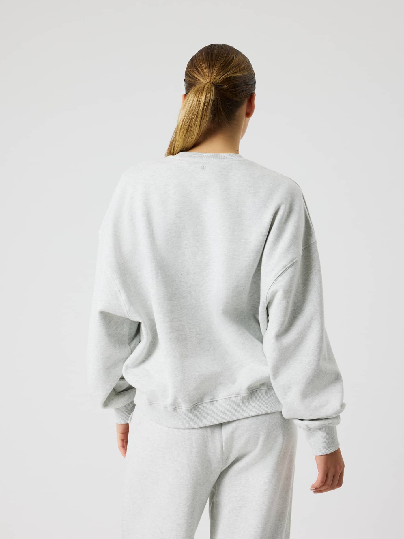 Back view of the Studio Oversized Sweatshirt in Ultra Light Grey Melange (Grey) with dropped shoulders, ideal for tennis. - Image 2