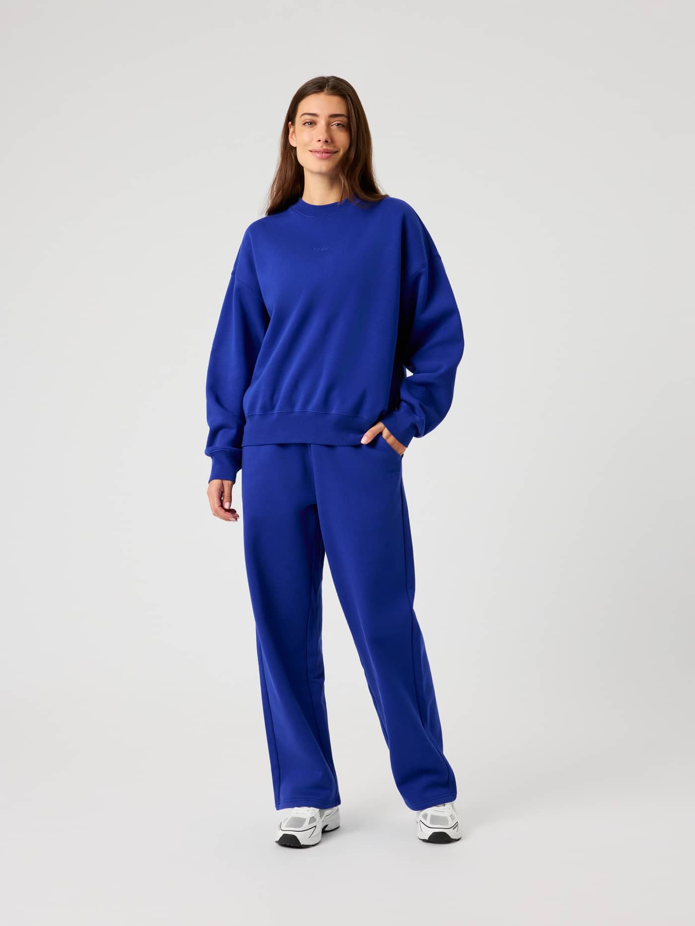 Full-body front view of a woman wearing the Björn Borg Studio Oversized Sweatshirt in Clematis Blue (Blue) and joggers. - Image 3