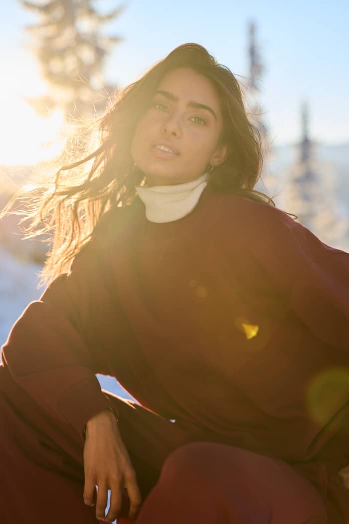 Studio Oversized Sweatshirt en Cabernet (rouge) porté en extérieur en plein soleil.