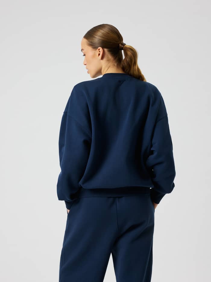 Back view of the Studio Oversized Sweatshirt in Dress Blues (Blue) featuring dropped shoulders and a relaxed fit.