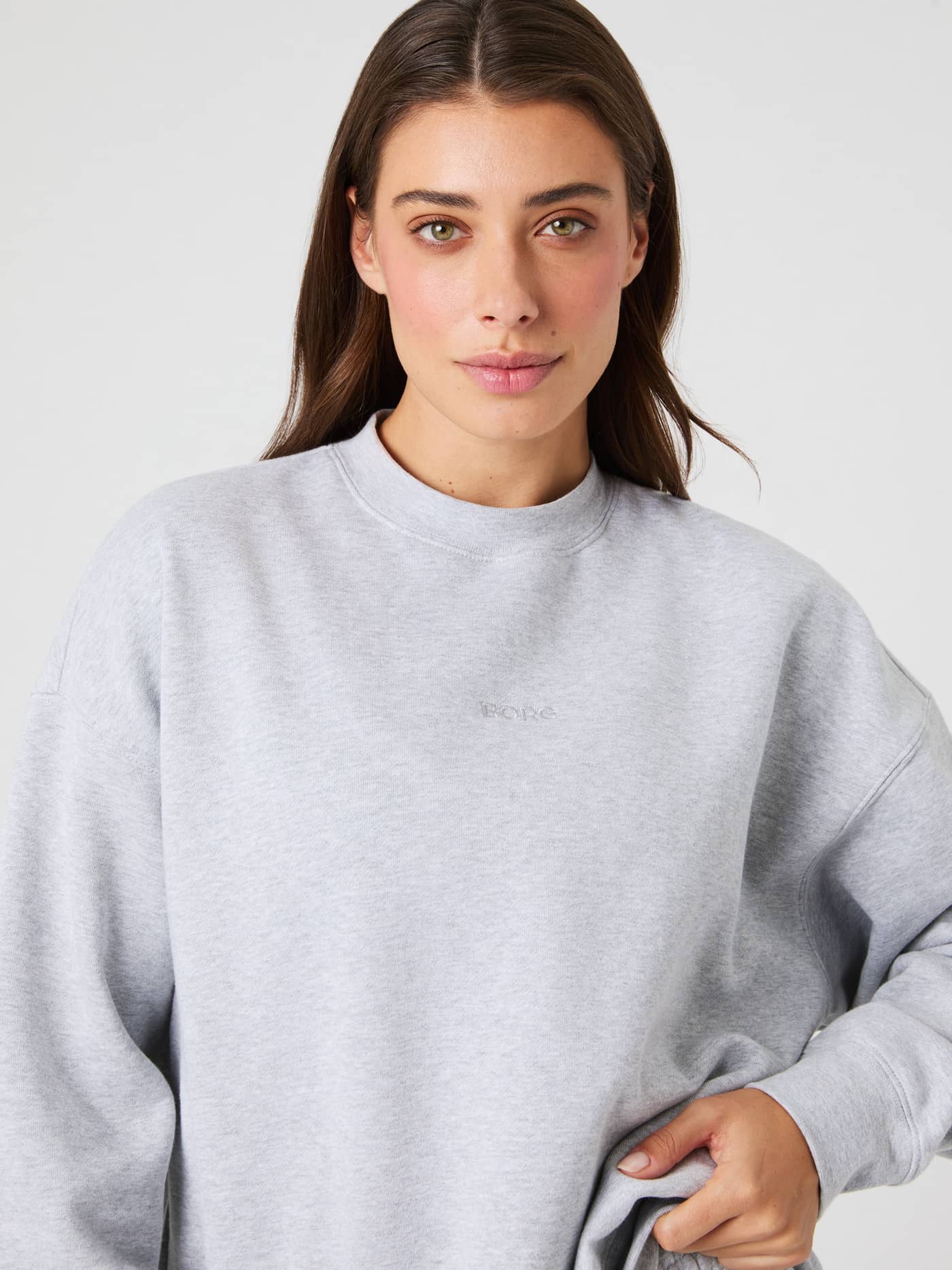 Close-up of a model wearing the Studio Oversized Sweatshirt in light grey melange. - Image 8
