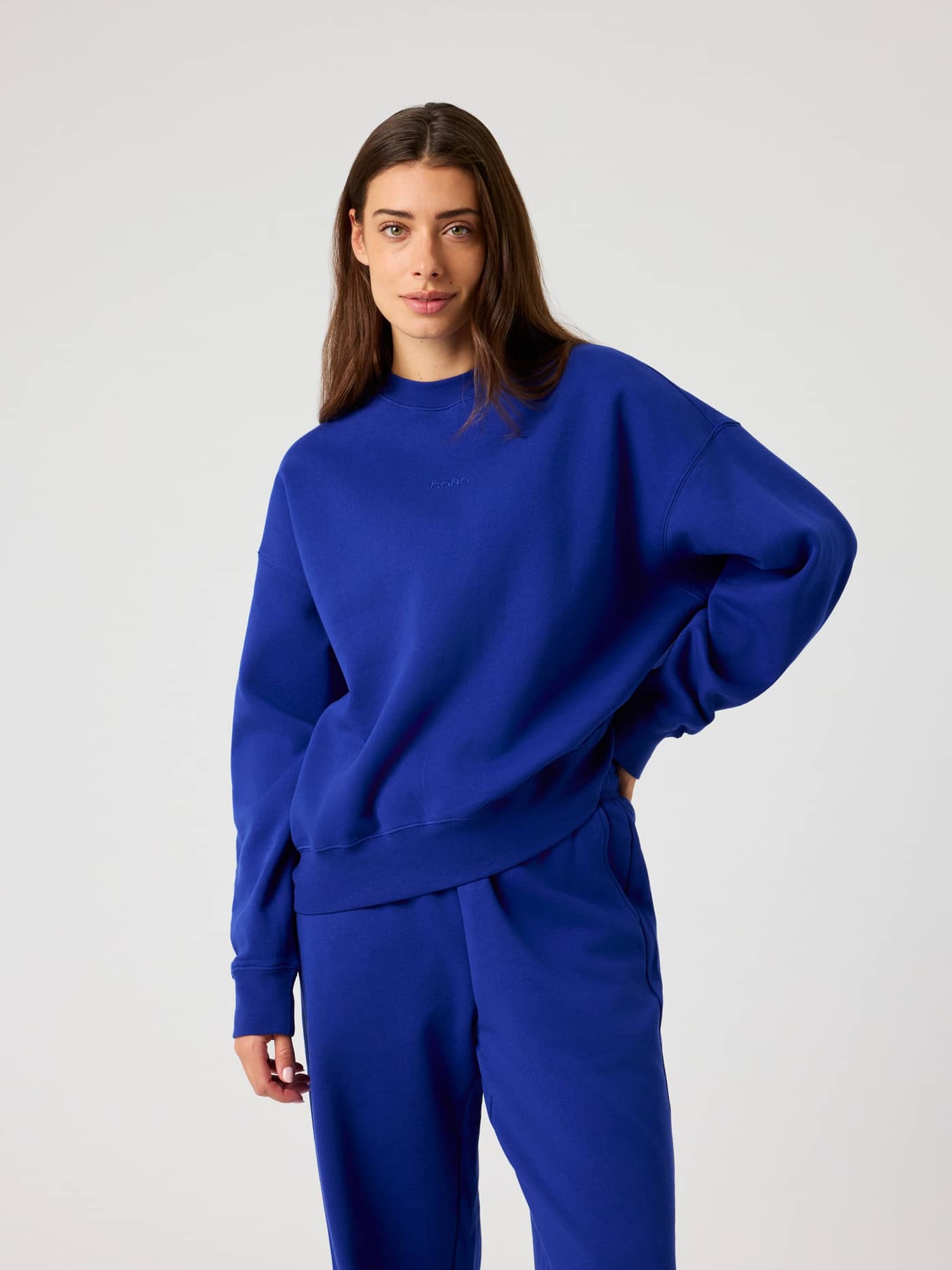 Front view of a model wearing the Studio Oversized Sweatshirt in Clematis Blue (Blue). - Image 1