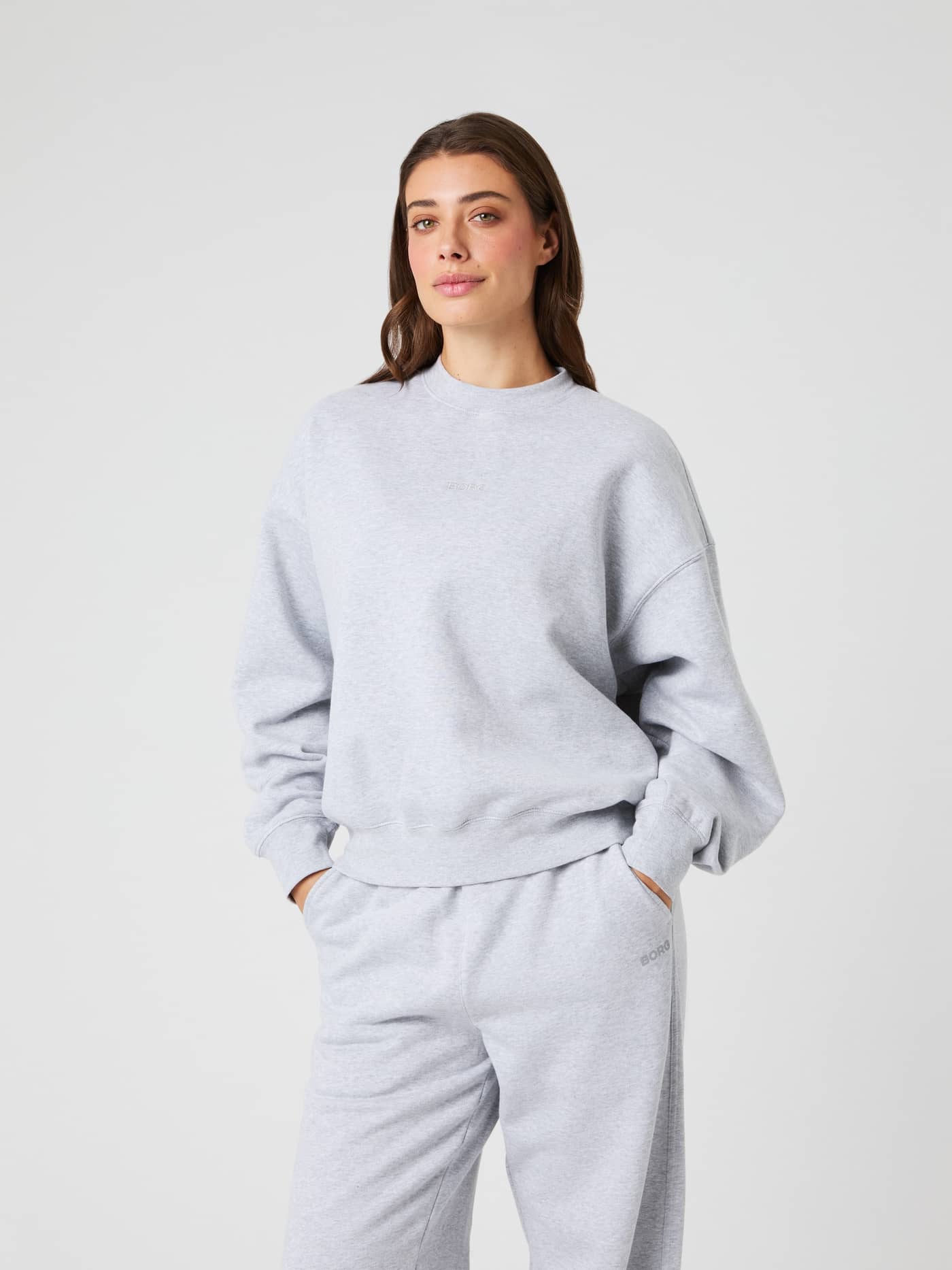 Model wearing the Björn Borg Studio Oversized Sweatshirt in light grey melange, shown from the front. - Image 2
