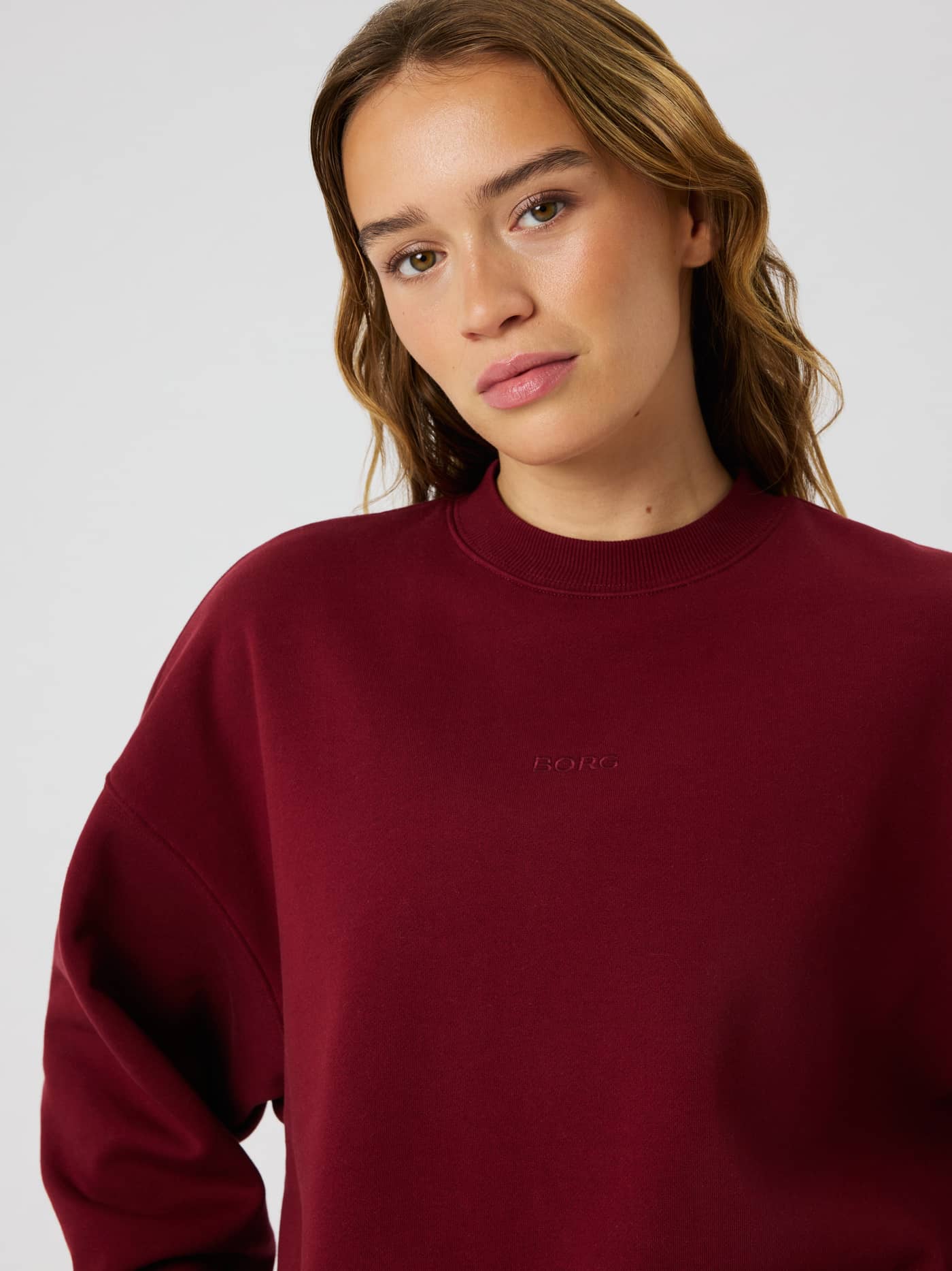 Närbild på Studio Oversized Sweatshirt i Cabernet (röd) med rund halsringning och lediga, sänkta axlar. - Image 4