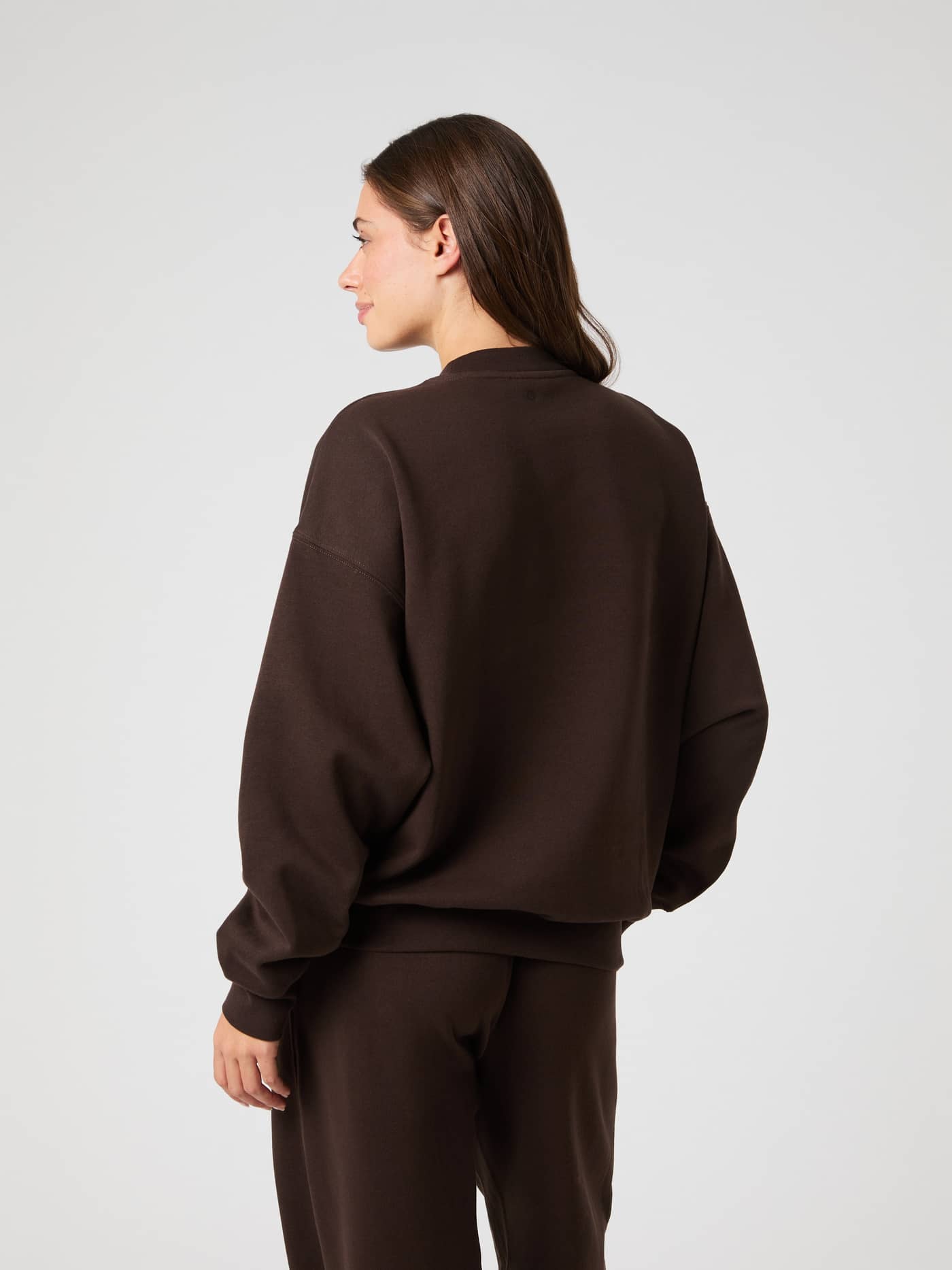 Model seen from the back wearing the brown Studio Oversized Sweatshirt, showing its relaxed and oversized fit. - Image 2