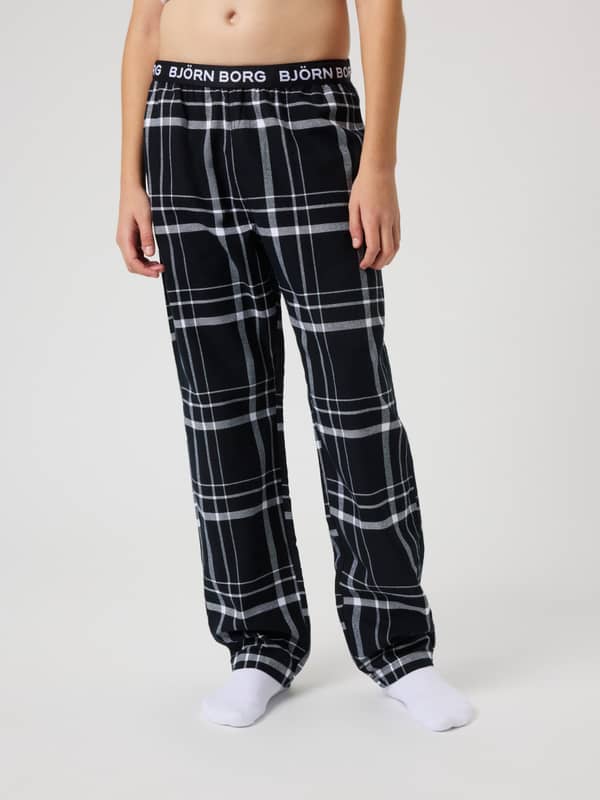 Front view of a kid wearing the relaxed fit Björn Borg Core Flannel Pyjama Pants in a checked Lounge Pattern (Black/White).