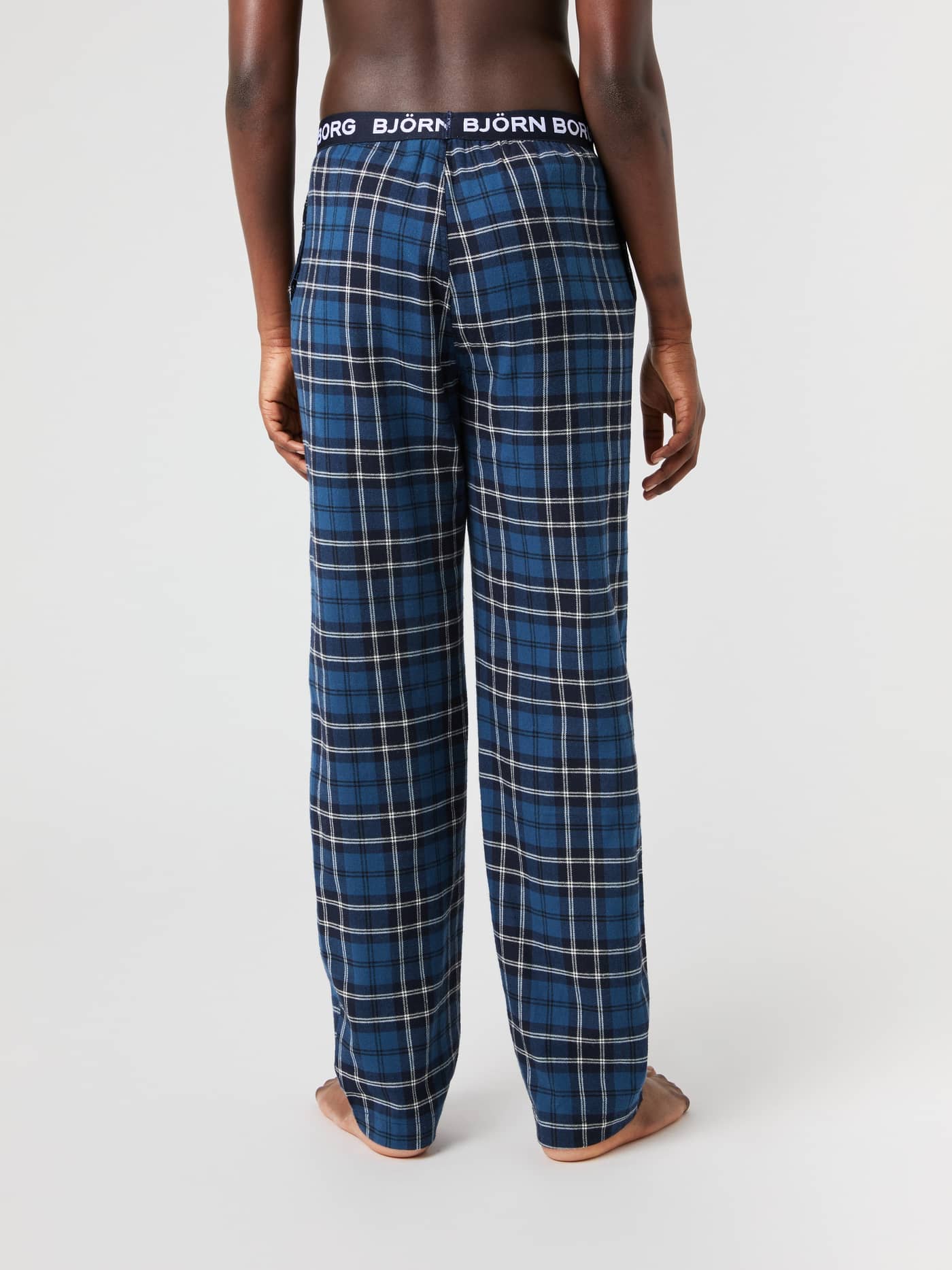 Model from behind wearing Björn Borg Core Flannel Pyjama Pants in a blue and black tartan pattern. - Image 2