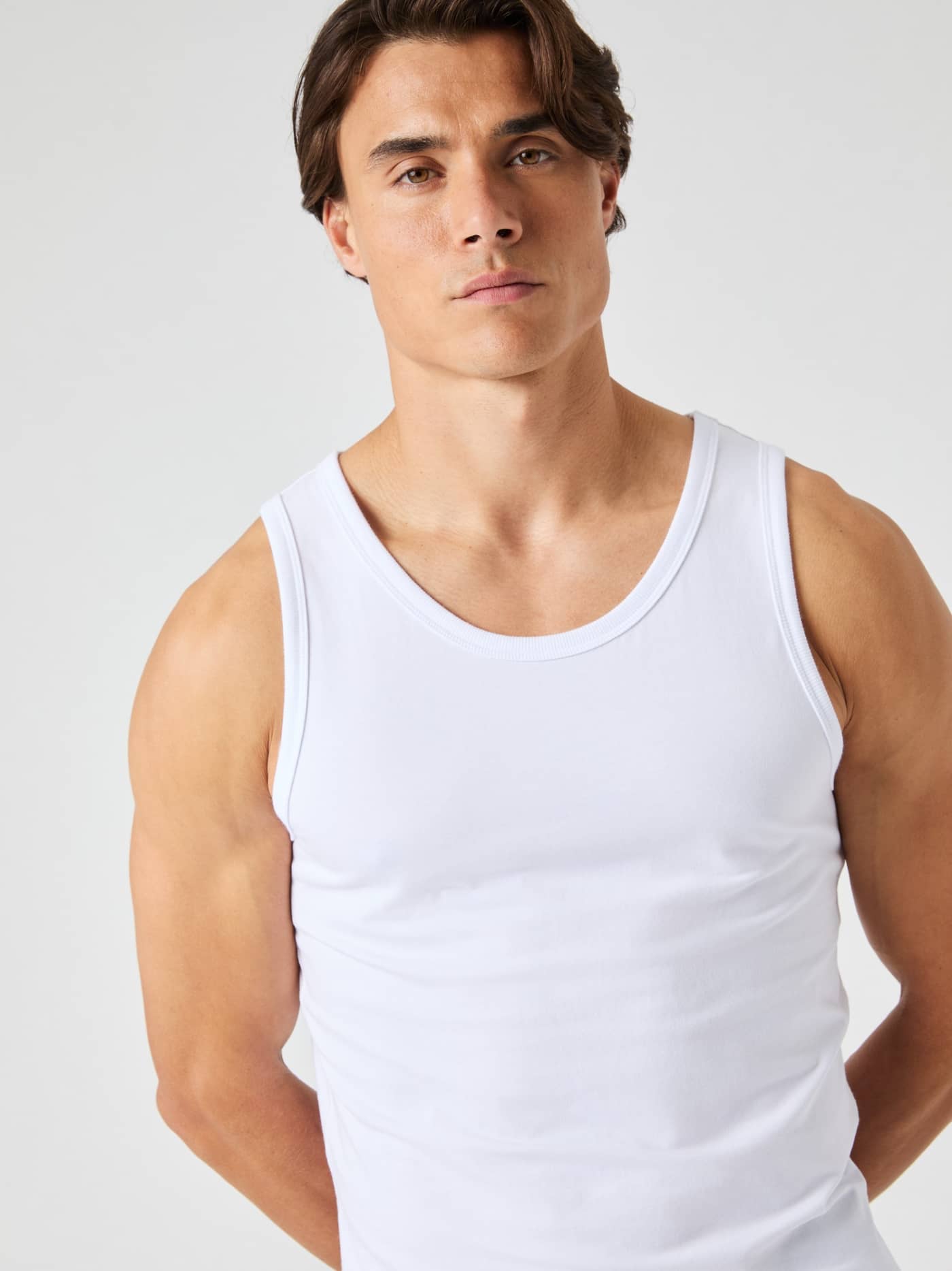 Front view of a man wearing the Björn Borg Core Slim Tank 2-pack in Brilliant White (White), a cotton slim fit for leisure. - Image 1