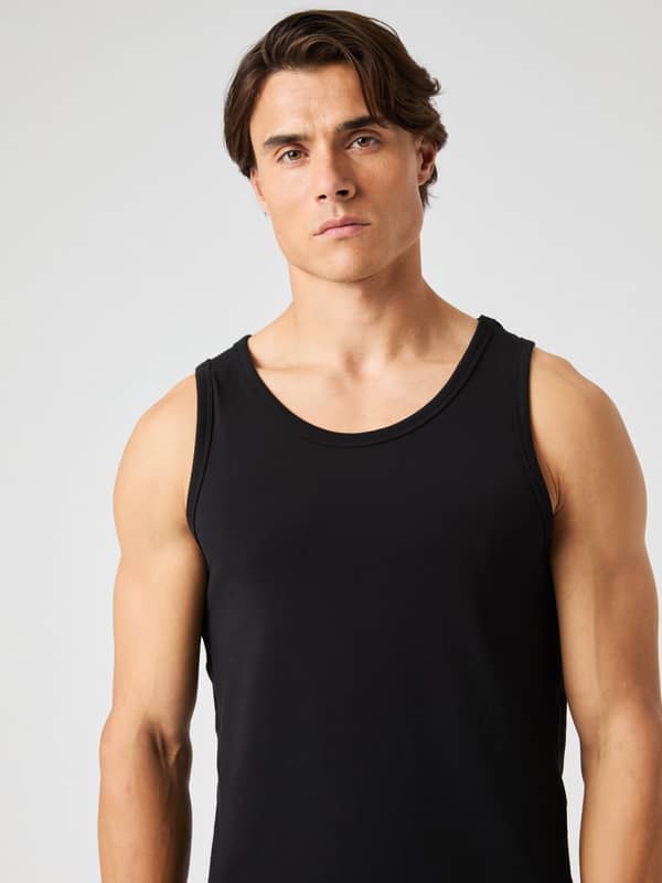 Front view of a man wearing the Björn Borg Core Slim Tank 2-pack in solid Black (black), featuring a stylish and slim fit.