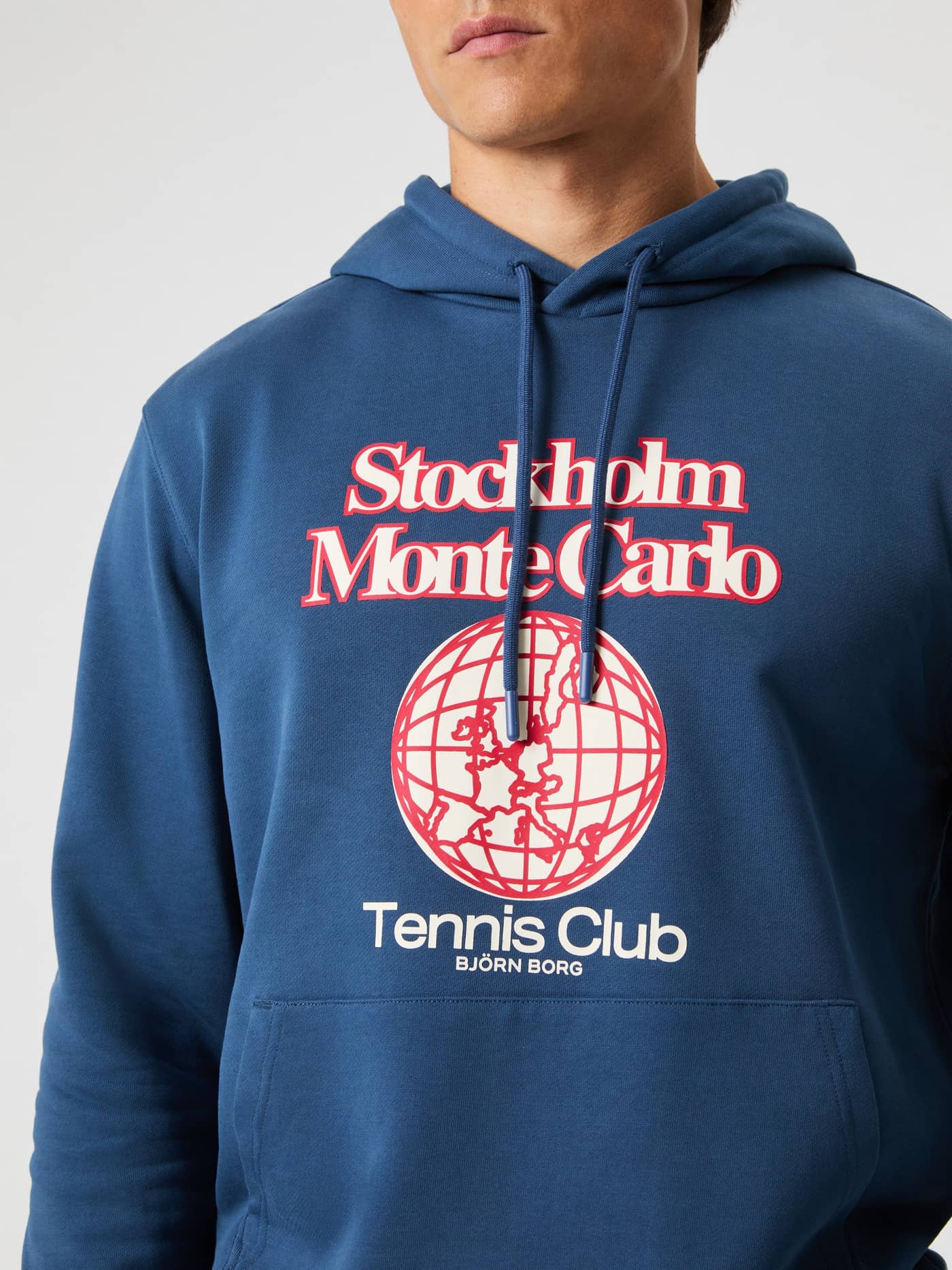 Close-up of a man in the relaxed fit cotton Björn Borg Classic Print Hoodie in Sargasso Sea (Blue) with a red tennis logo. - Image 4