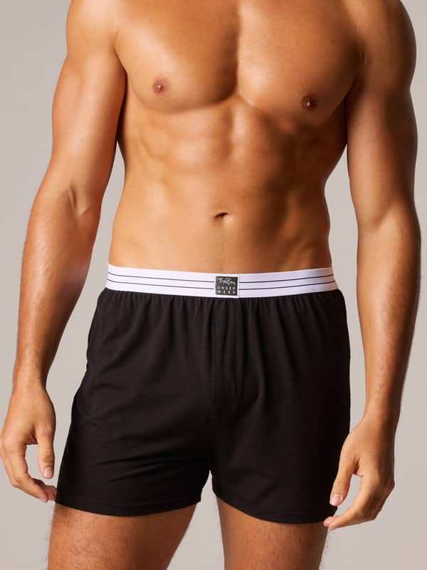 Front view of a model wearing black Viscose Cotton Blend Jersey Boxers Shorts 2-pack with a striped elastic waistband.