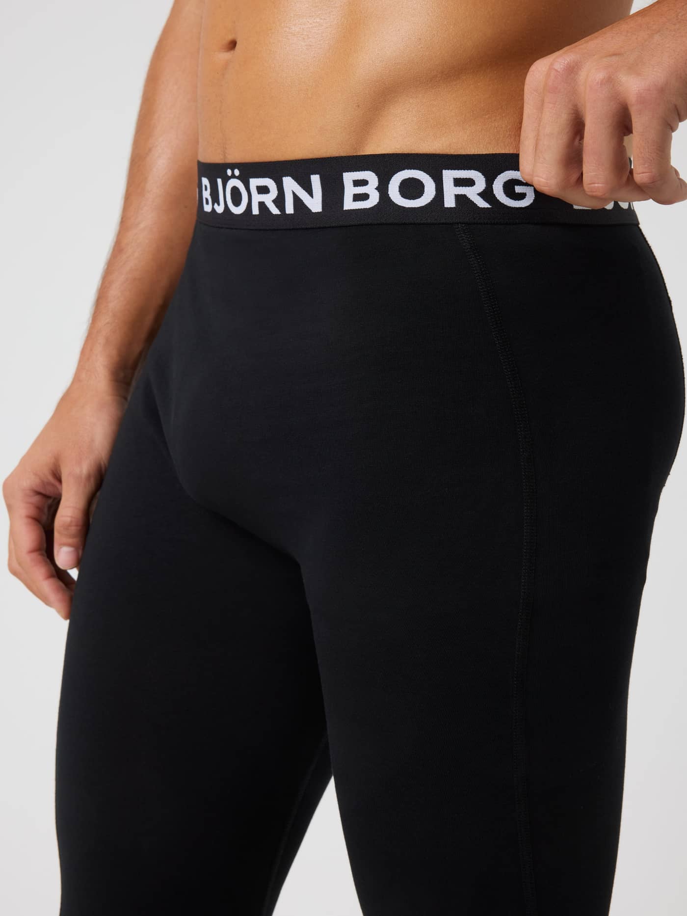 Close-up of the black Cotton Stretch Long Johns 1-pack for men, featuring a white logo on the soft elastic waistband. - Image 4