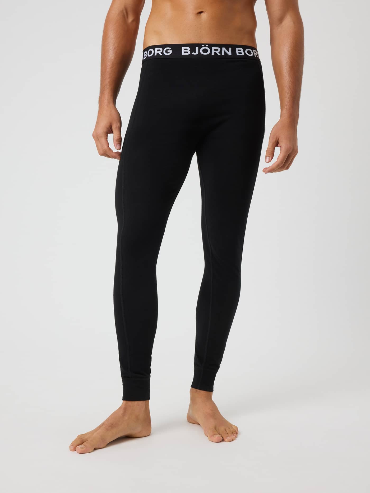 Front view of a man wearing the black Björn Borg Cotton Stretch Long Johns 1-pack with a soft logo elastic waistband. - Image 2