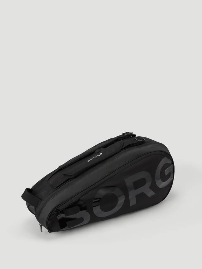 Ace Tennis Bag i Black Beauty (Svart) sedd från sidan med en stor ton-i-ton-logotyp på slitstark polyester. - Image 3