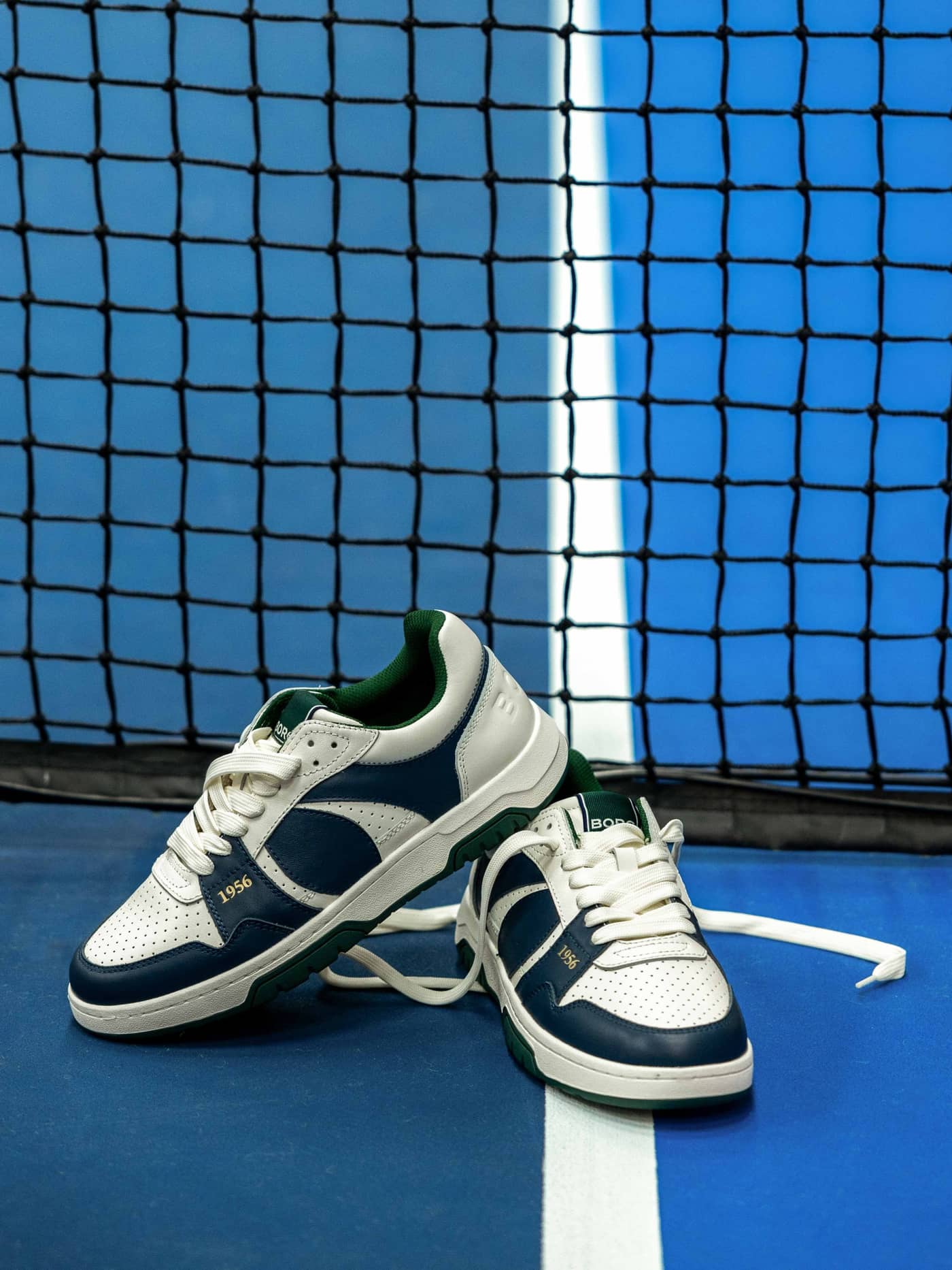Men's Ollie Leather Sneakers in off white, navy, and green cow leather, styled for performance on a tennis court. - Image 1