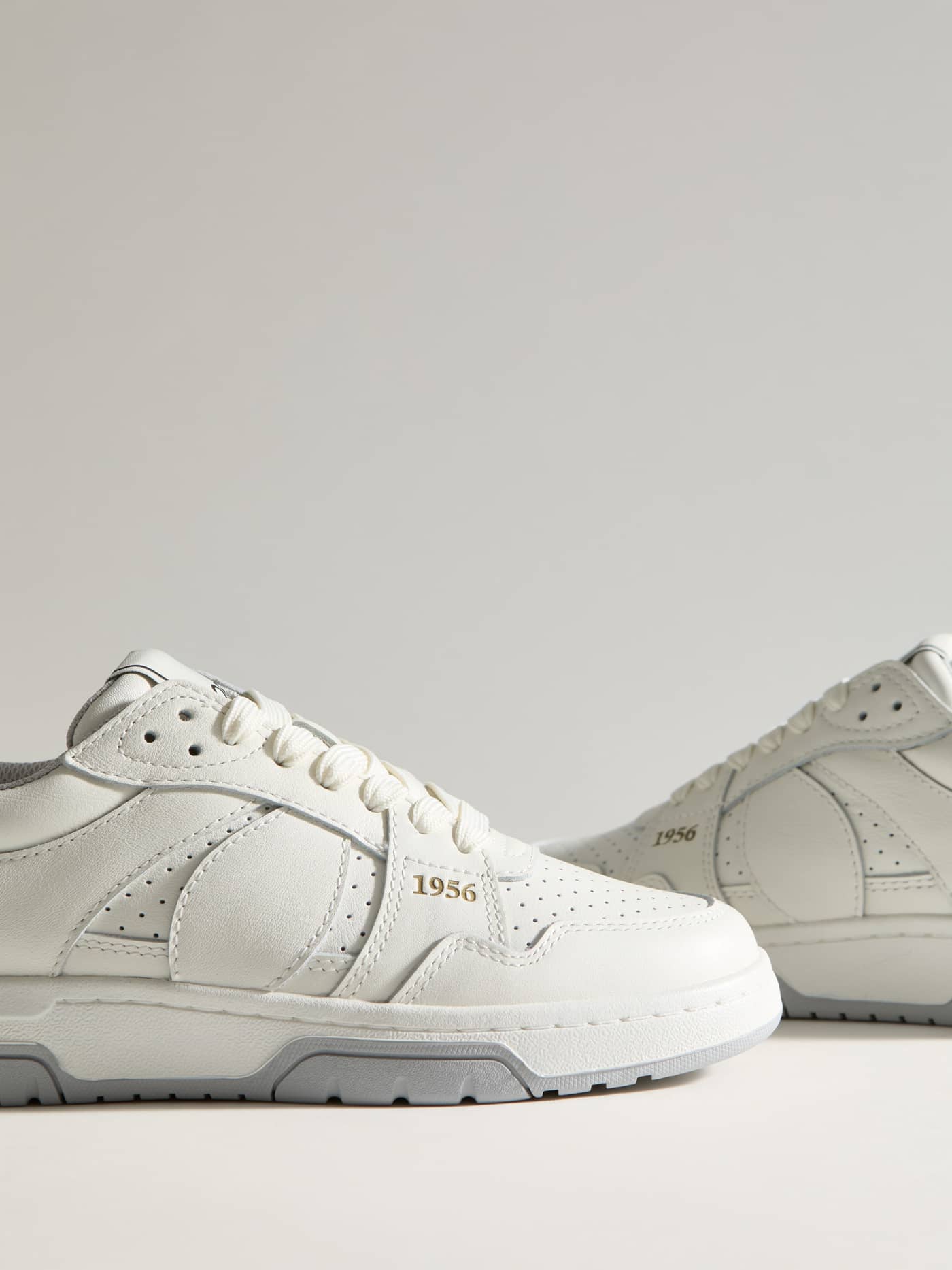 Men's Ollie Leather Sneakers in white featuring perforated cow leather, a gold 1956 logo and functional tennis style. - Image 1