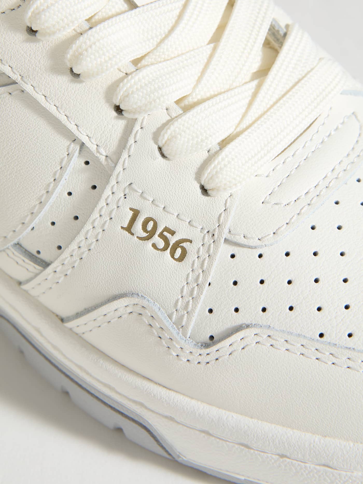 Detailed close-up of the white Men's Ollie Leather Sneakers in cow leather, featuring perforated tennis style and gold 1956. - Image 5