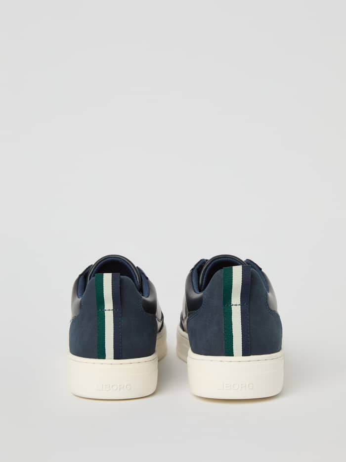 Achteraanzicht van de marineblauwe Men's Game Low Sneakers met een gestreepte hiel en functionele tennisstijl. - Image 3