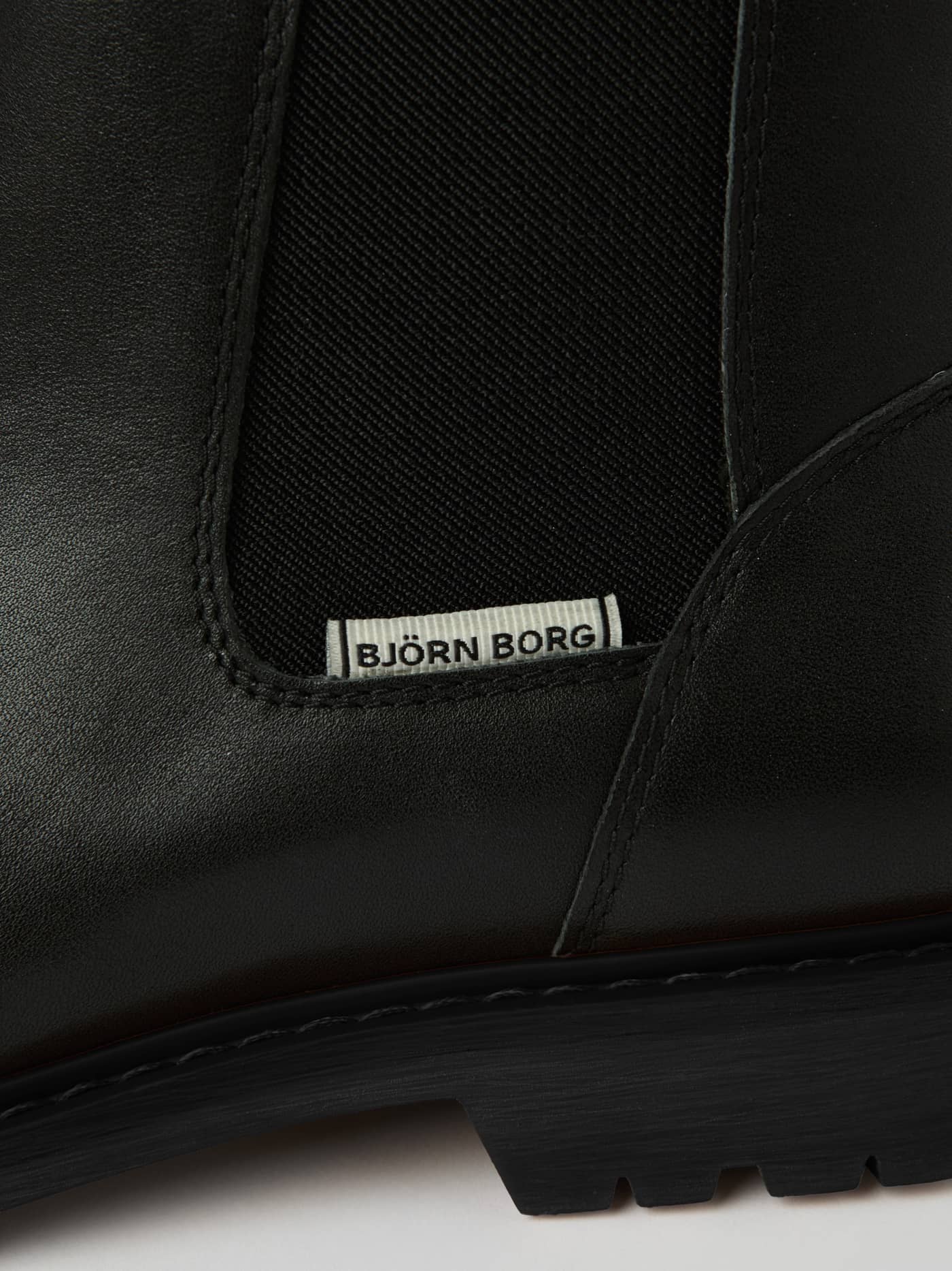 Gros plan des Men's Chelsea Boots en cuir de vache noir avec élastique et logo Björn Borg blanc. - Image 4