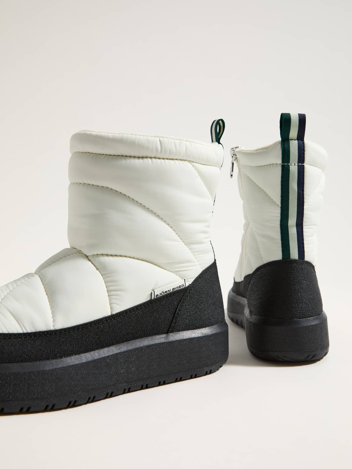 Side view of the Women's Alpine Boots in White featuring a quilted leisure design, black platform sole, and white logo. - Image 1