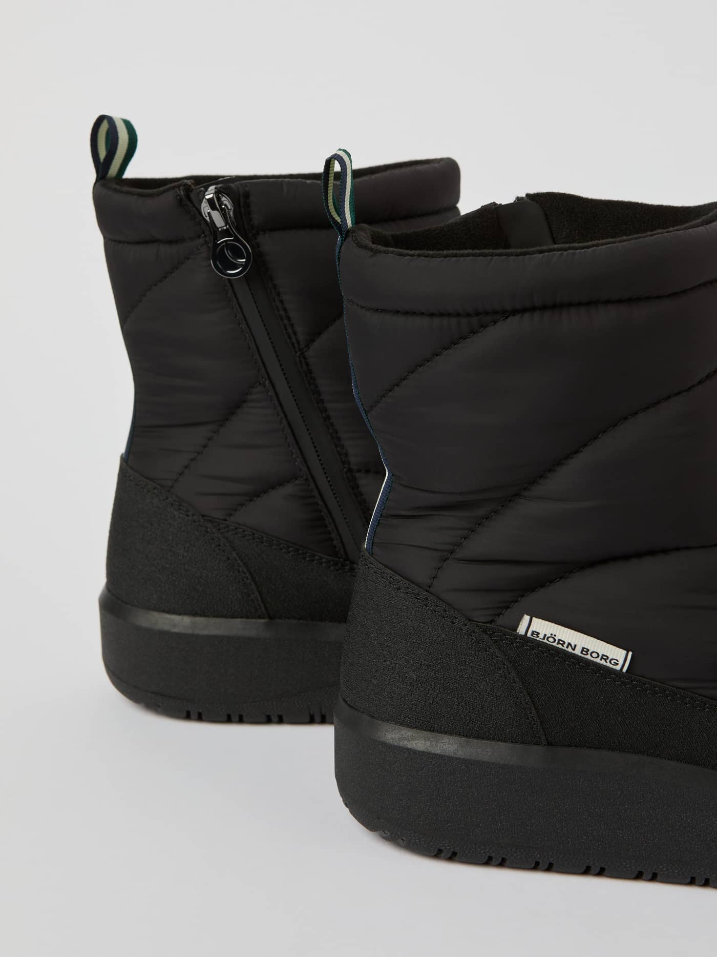 Vue latérale détaillée des Women's Alpine Boots Noir, design matelassé, zip latéral et étiquette logo blanche. - Image 4