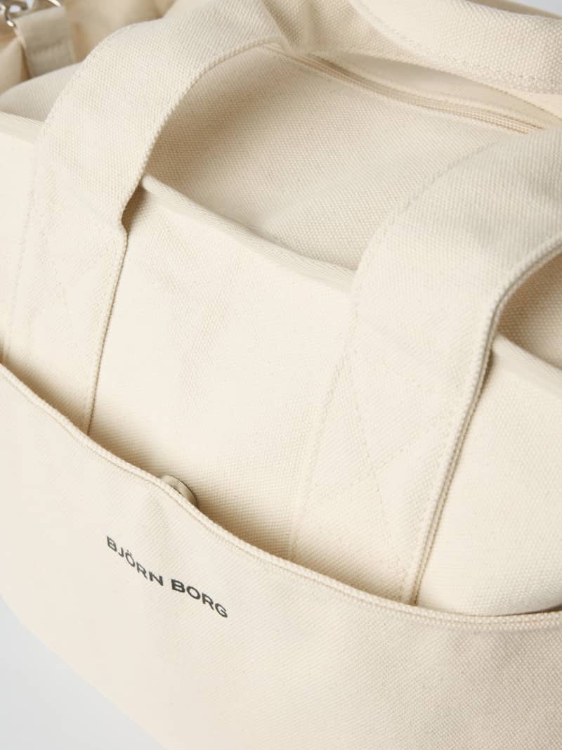 Gros plan détaillé du Studio Canvas Tote 34L en Egret (Blanc) en toile de coton avec logo Björn Borg noir. - Image 3