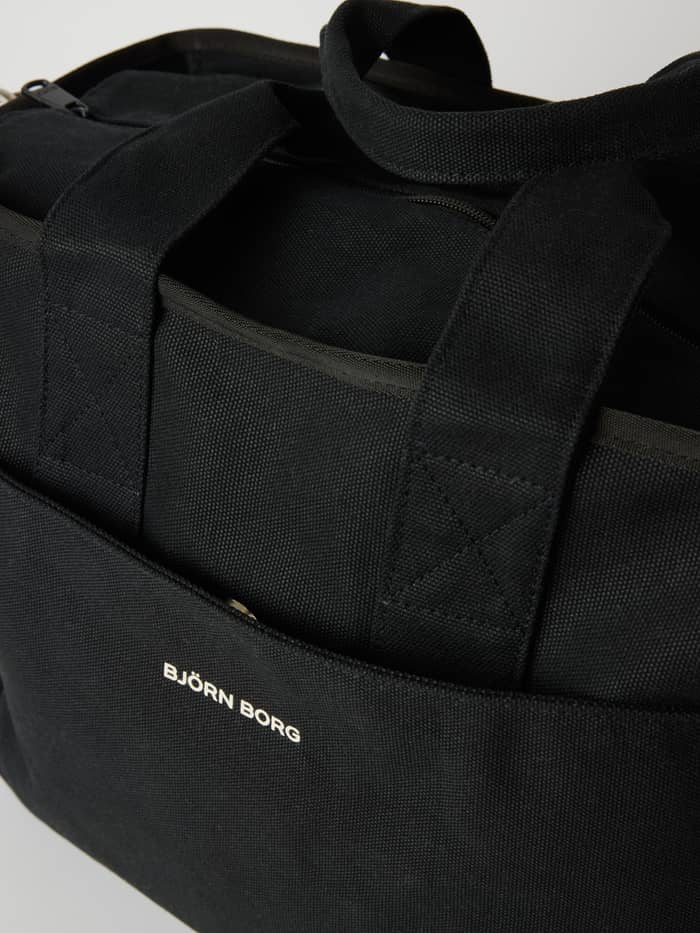 Nærbillede af Studio Canvas Tote 34L i bomuld i Black Beauty (Sort) med et hvidt logo. - Image 3