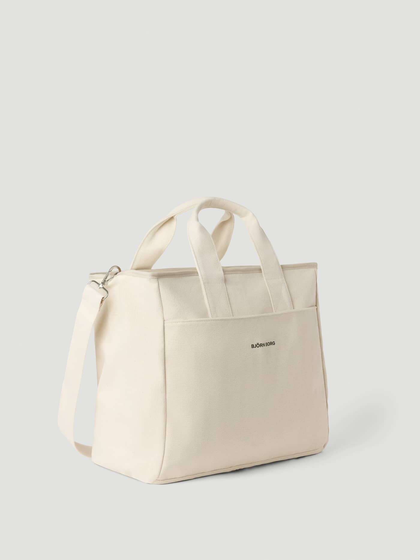 Studio Canvas Tote 34L in Egret (White) crafted from cotton canvas with a stylish black logo and versatile strap. - Image 2