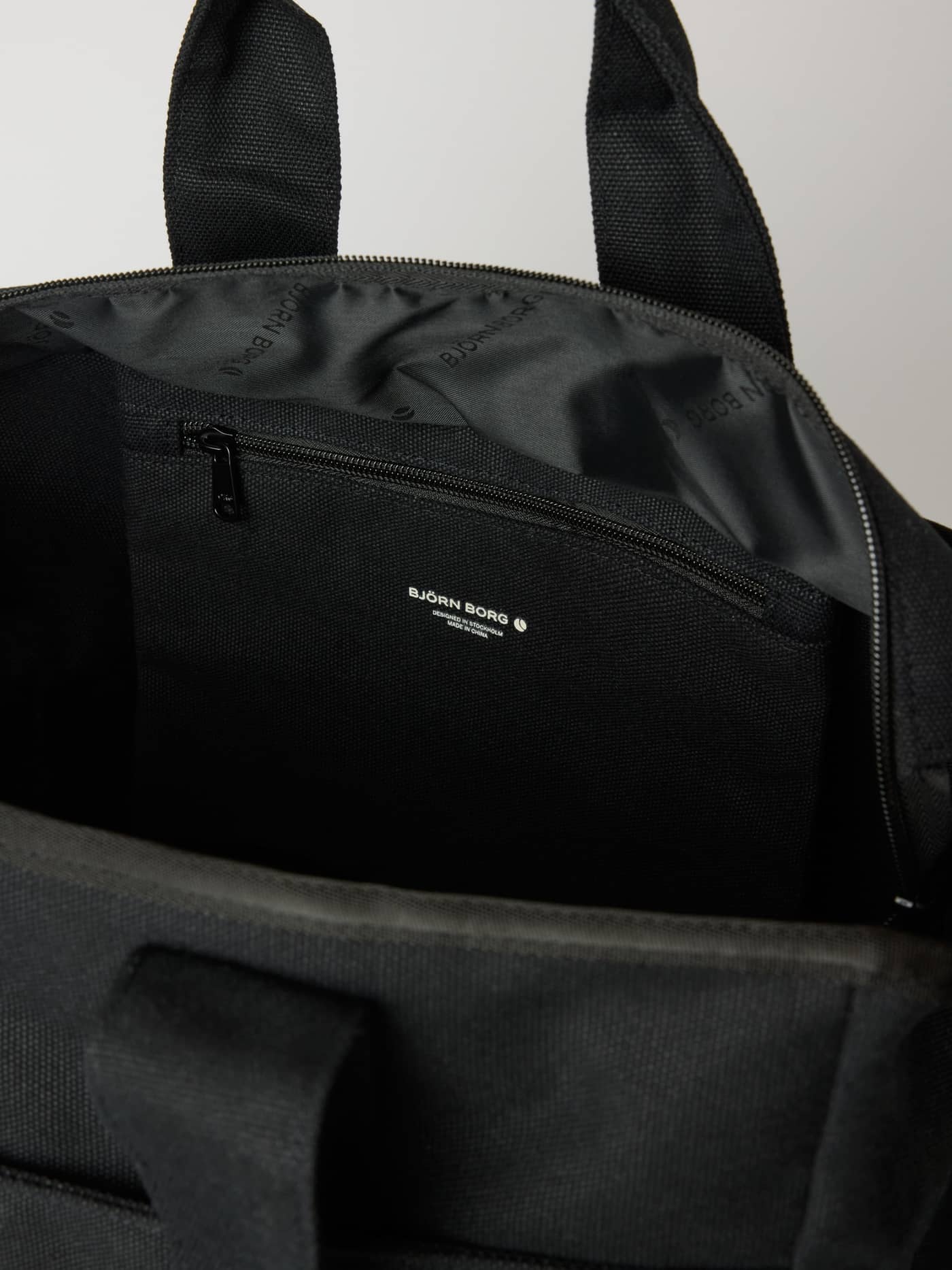 Interieur van de katoenen Studio Canvas Tote 34L in Black Beauty (Zwart) met een ritsvak en wit Björn Borg-logo. - Image 4