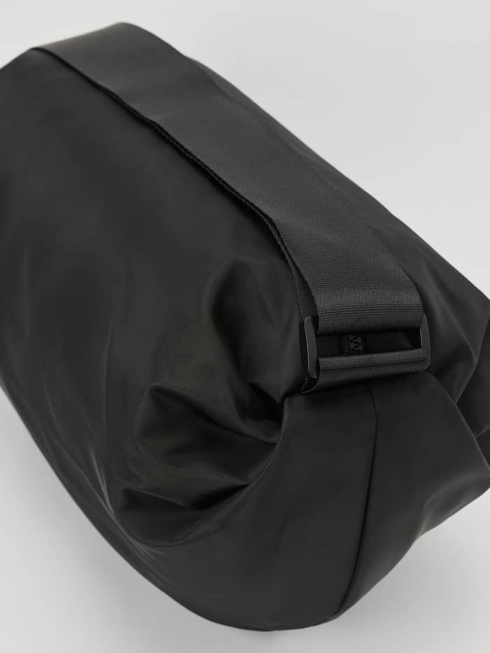 Close-up side view of the training Borg Active Shoulder Bag 9L in Black Beauty (Black) made from recycled polyester. - Image 3