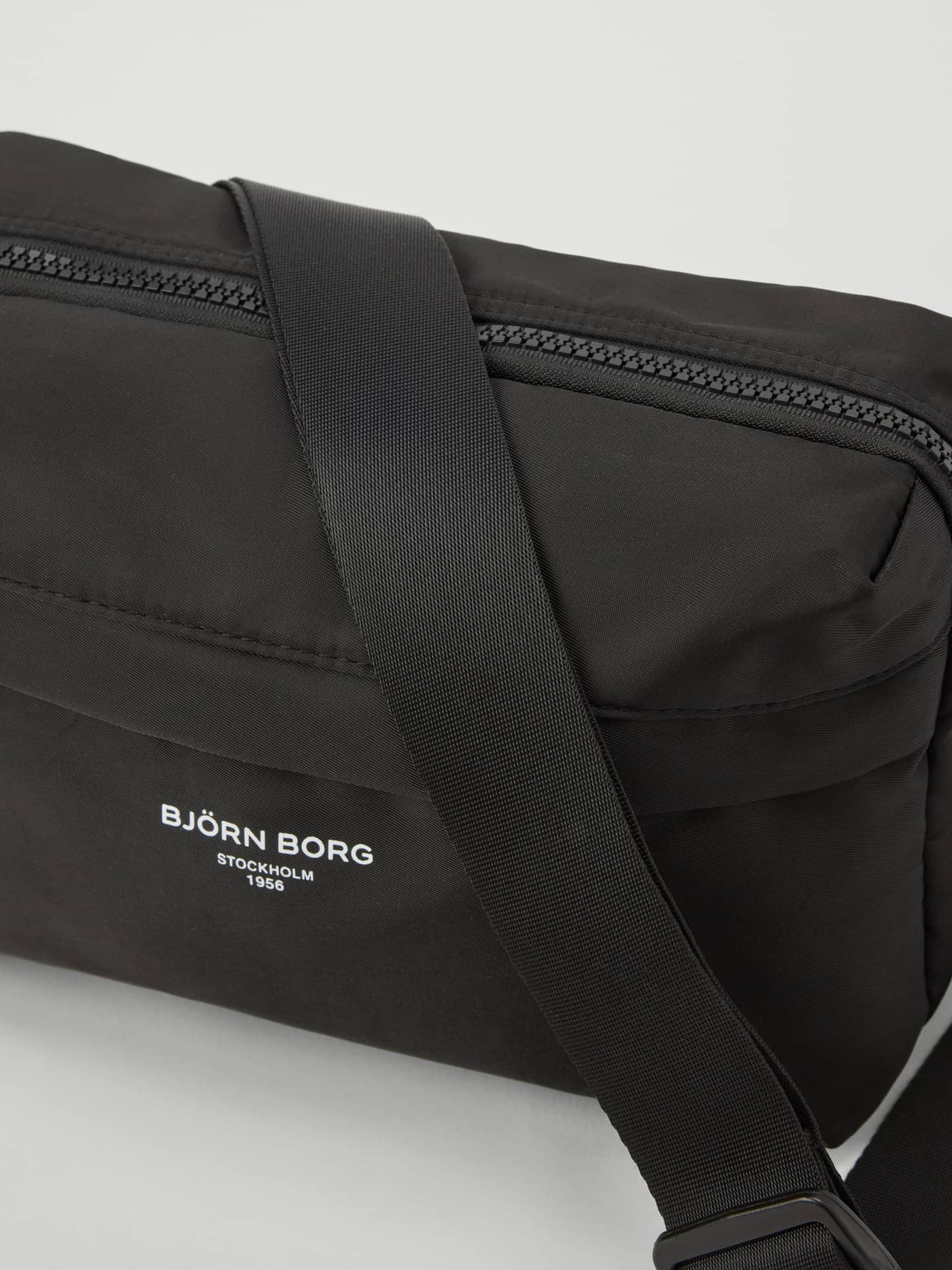 Gedetailleerde close-up van de Borg Active Crossover Bag in Black Beauty (Zwart) met wit logo en trainingsmateriaal. - Image 3