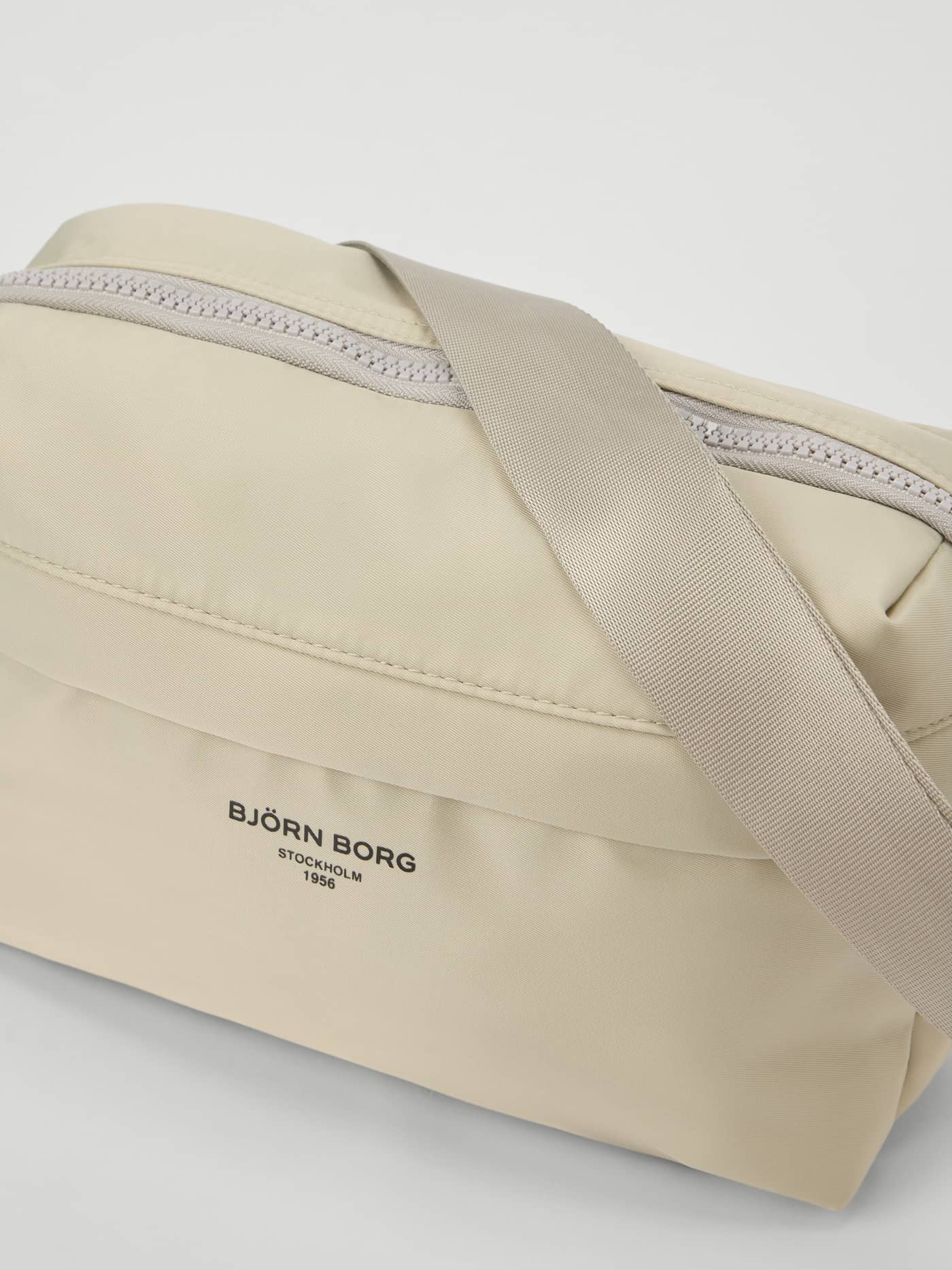 Närbild på Borg Active Crossover Bag 4L i Silver Birch (Vit) med svart logotyp, perfekt för träning. - Image 3