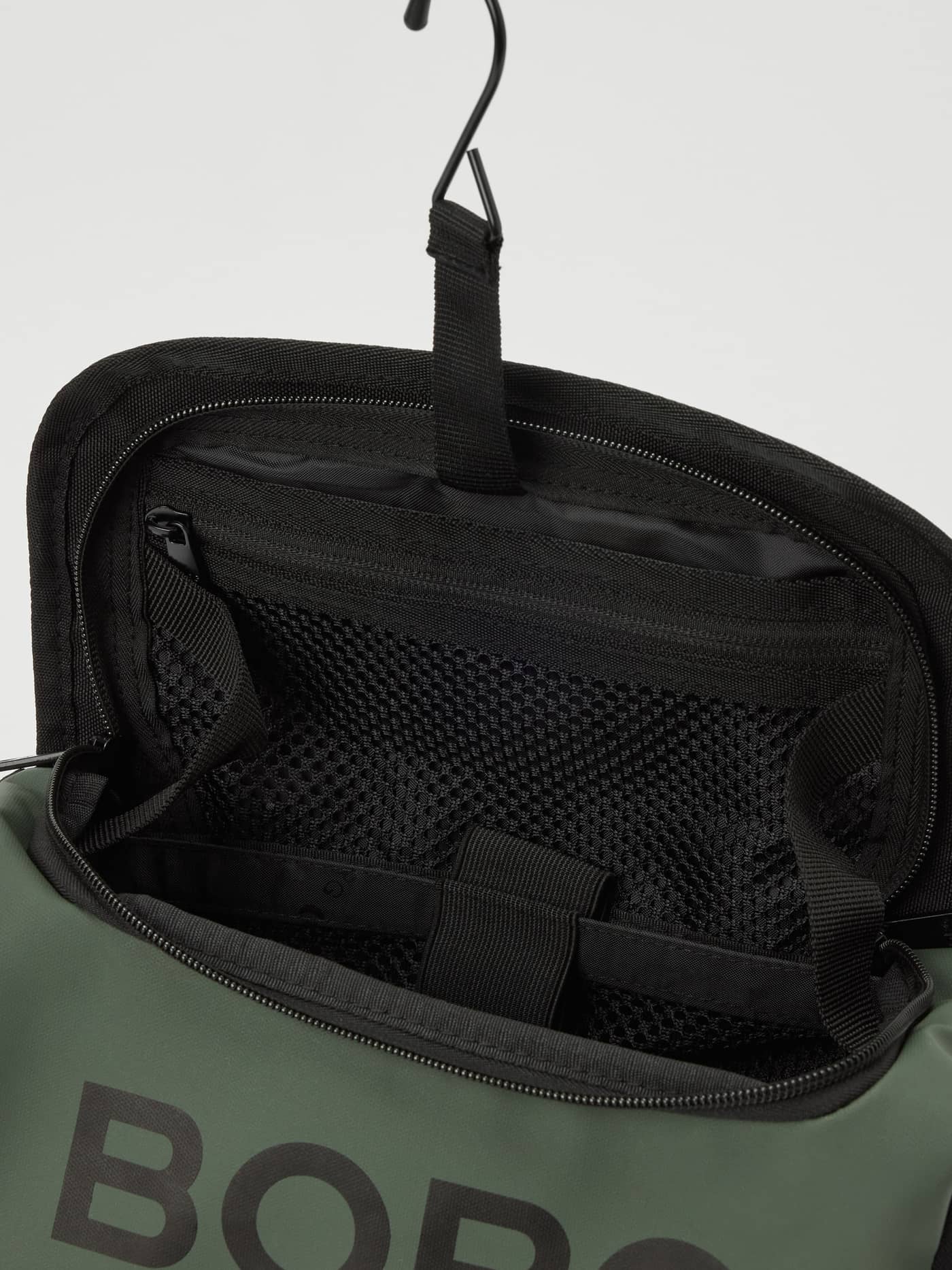Detailed view of the Travel Wash Bag in Mountain View (Green) showcasing its interior mesh pockets and hook. - Image 3