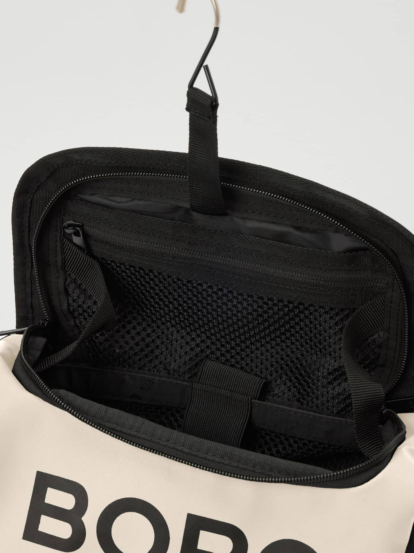 Hängande Travel Wash Bag i Bone White (Vit) med en svart logotyp och en praktisk invändig nätficka. - Image 3