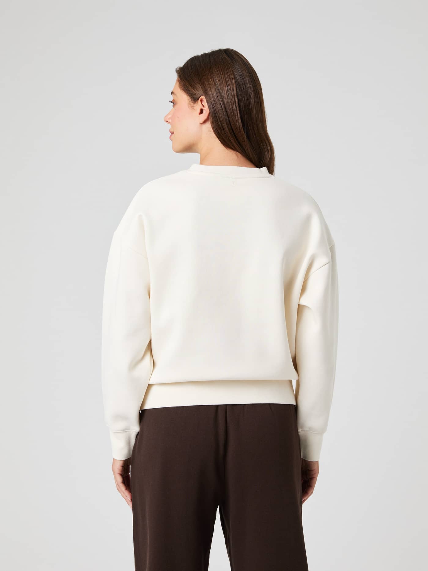 Back view of a model wearing the Borg Boyfriend Sweatshirt in Tofu (White) with a relaxed, oversized fit. - Image 3