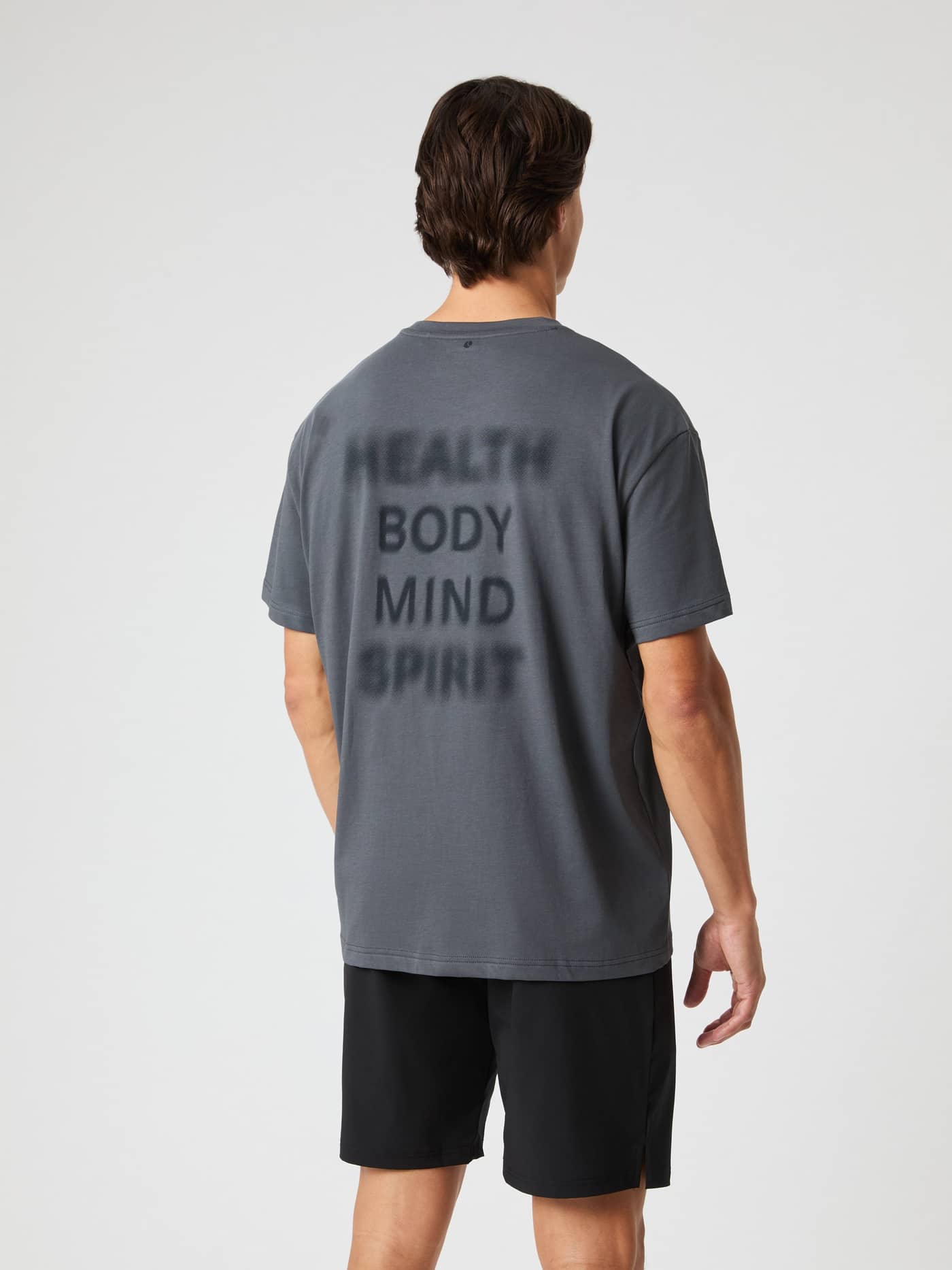 Bakside av mann i Borg Gym Oversized T-Shirt i Asphalt (Grå) med svart tekst for funksjonelle treningsøkter. - Image 3