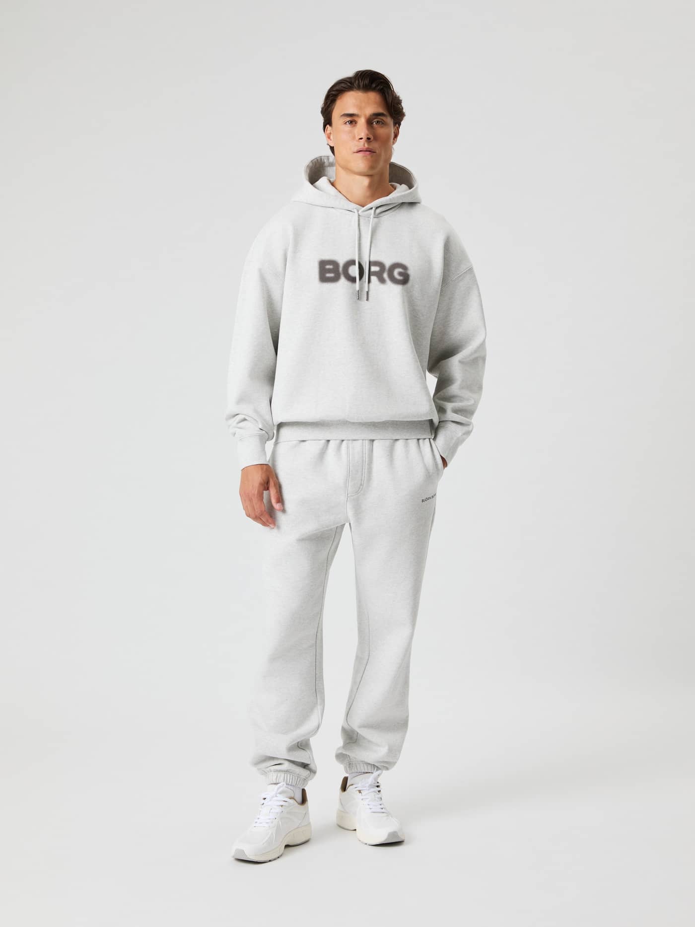 Vista frontal de hombre con la Borg Oversized Hoodie en Ultra Light Grey Melange (Gris) con logo oscuro y ajuste relajado. - Image 6