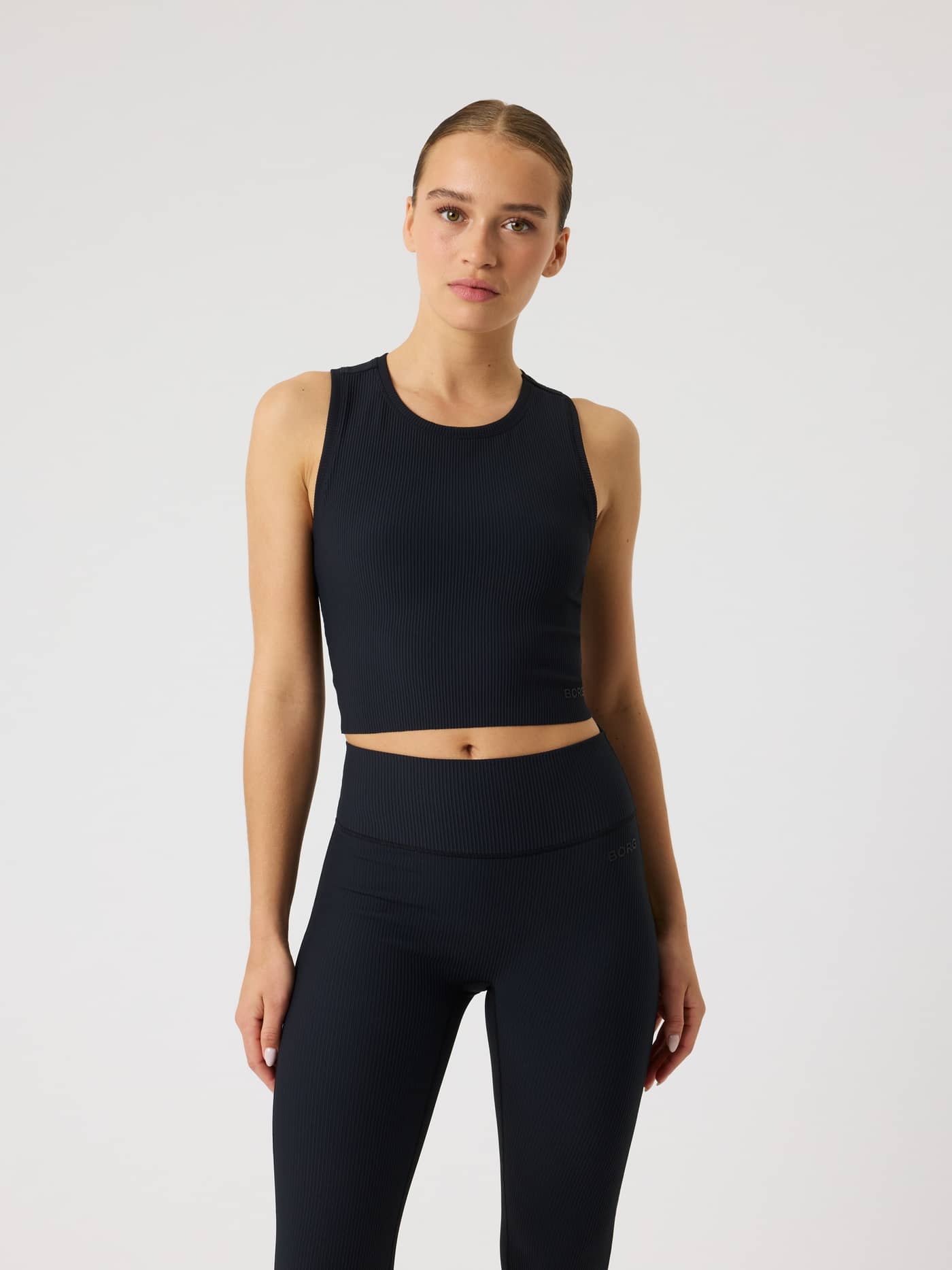 Vorderansicht eines Models im Björn Borg Studio Ribbed Cropped Tank Top in Black Beauty (Schwarz) für das Training. - Image 2