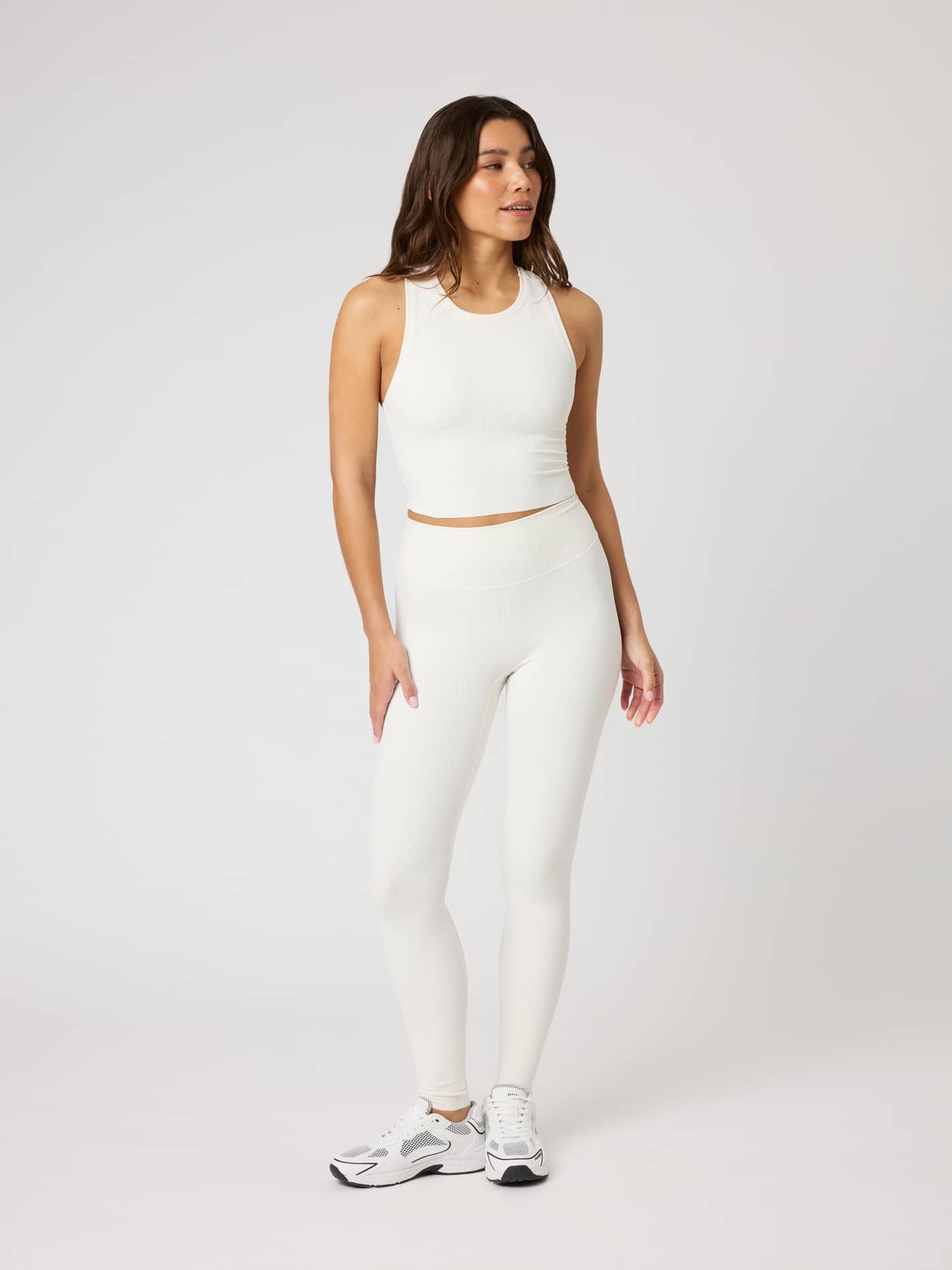 Full-body front view of a model in the Studio Ribbed Cropped Tank Top in Tofu (White) and matching leggings for training. - Image 3