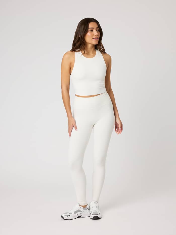 Full-body front view of a model in the Studio Ribbed Cropped Tank Top in Tofu (White) and matching leggings for training. - Image 3