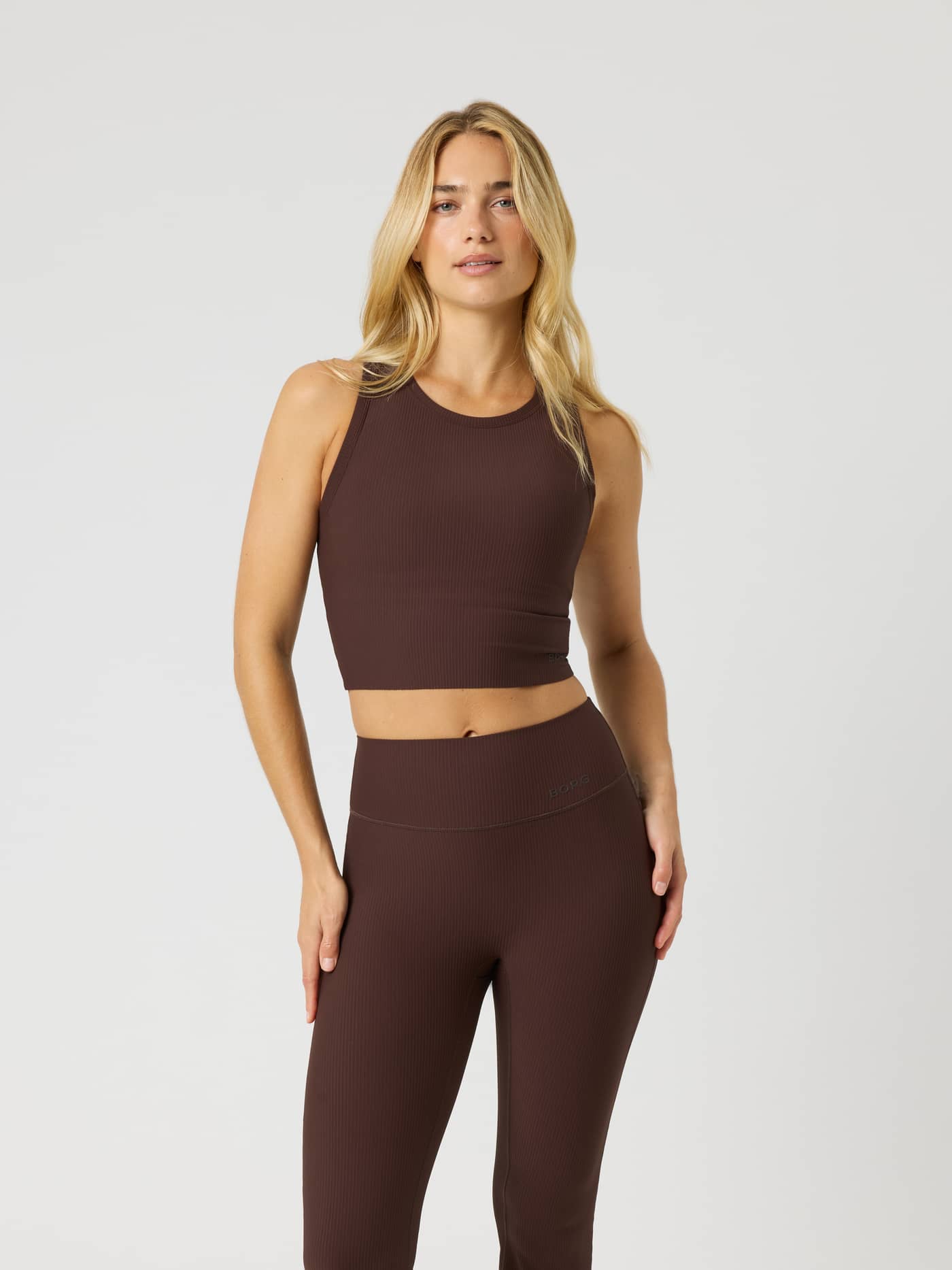 Front view of a model wearing the Björn Borg Studio Ribbed Cropped Tank Top in Coffee Bean (Brown) for a sleek training fit. - Image 3