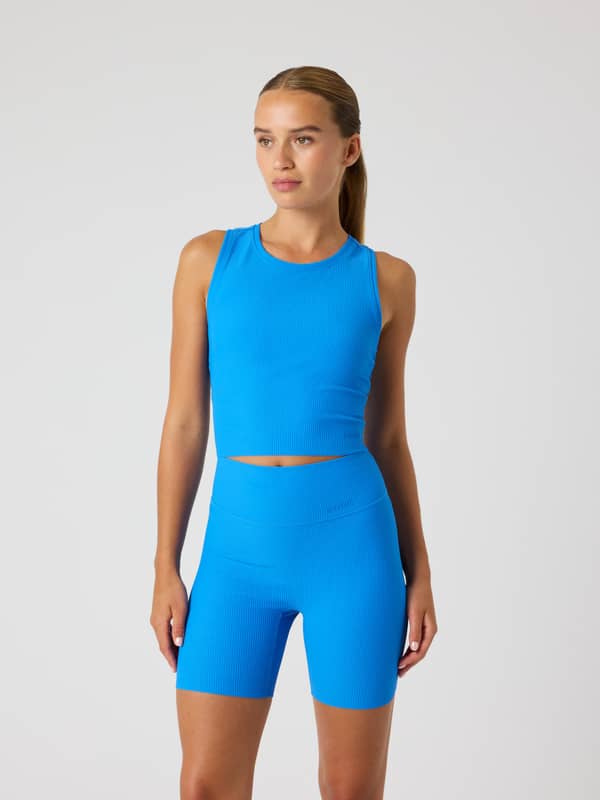 Vue de face du Studio Ribbed Cropped Tank Top Palace Blue (Bleu) en polyamide recyclé pour un entraînement stylé et ajusté.