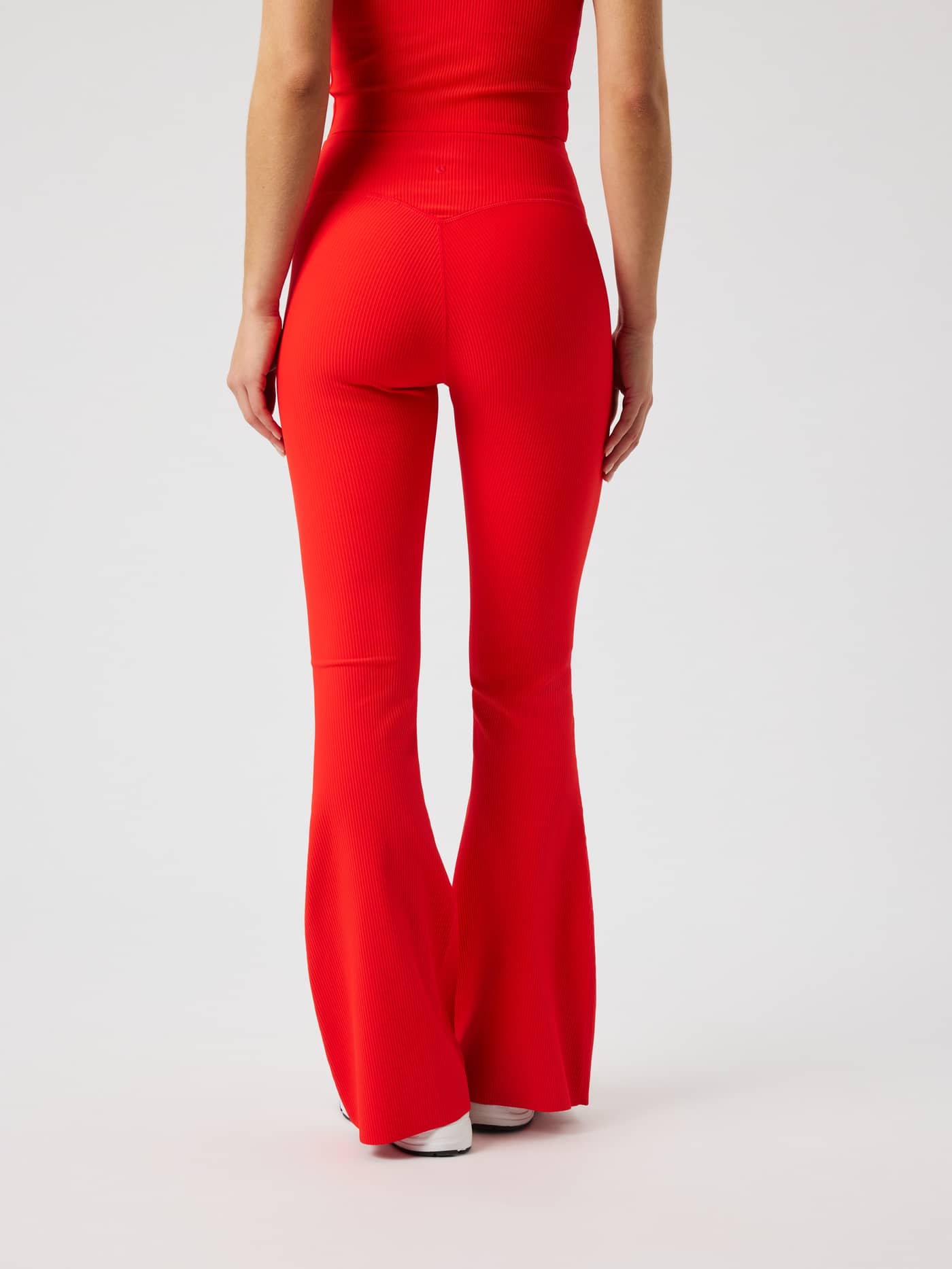 Back view of the Studio Ribbed Flare Tights Regular in Flame Scarlet (Red) featuring a flared training fit. - Image 3