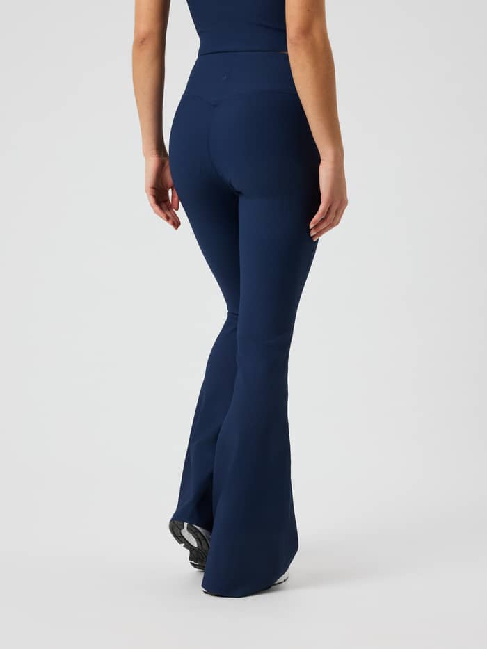 Bagfra af Studio Ribbed Flare Tights Regular i Dress Blues (blå) med et ribbet design og svajende ben.
