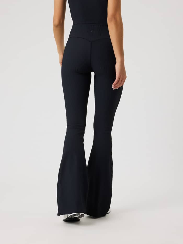 Rückansicht der Studio Ribbed Flare Tights Regular in Black Beauty (Schwarz) mit stylishem Schlag für das Training. - Image 4