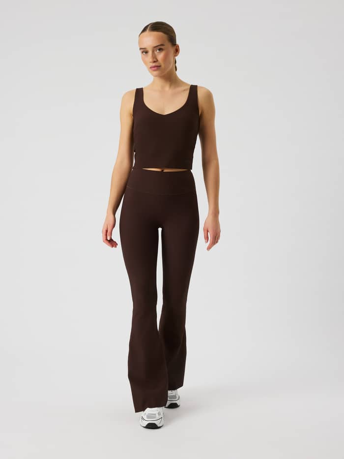 Full-body front view of Studio Ribbed Flare Tights Regular in Coffee Bean (Brown) with a flared training leg and tonal logo.