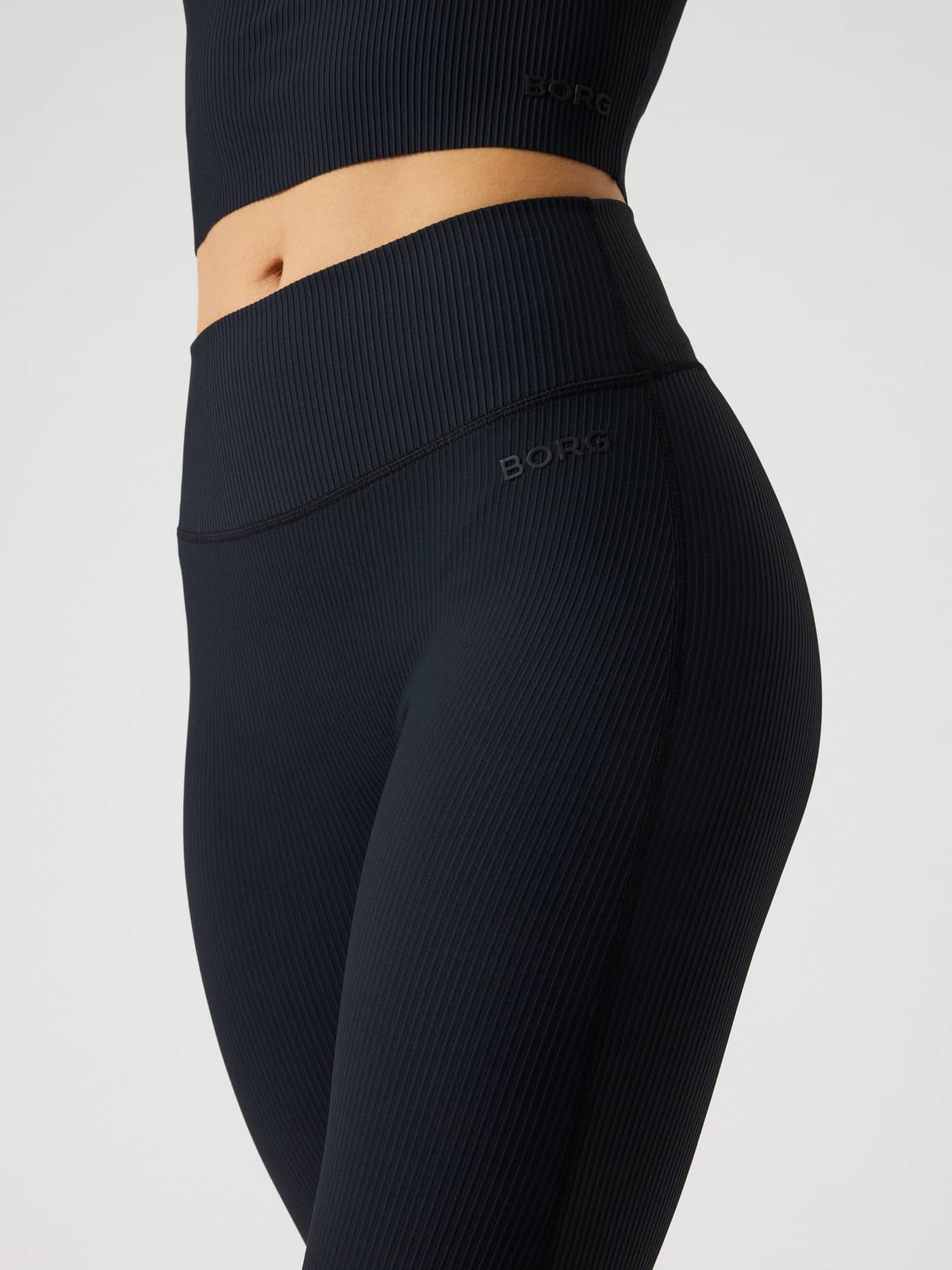 Side view of the Studio Ribbed Flare Tights Regular in Black Beauty (Black) for training, featuring a black BORG logo. - Image 5