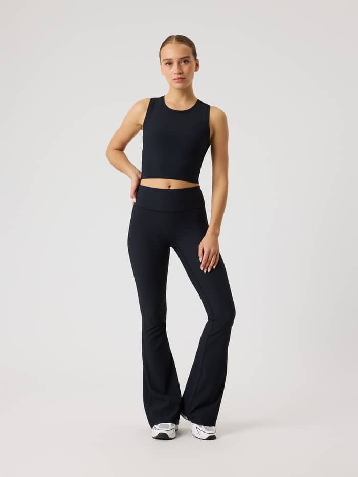 Modell framifrån i Studio Ribbed Flare Tights Regular i Black Beauty (Svart) för träning.