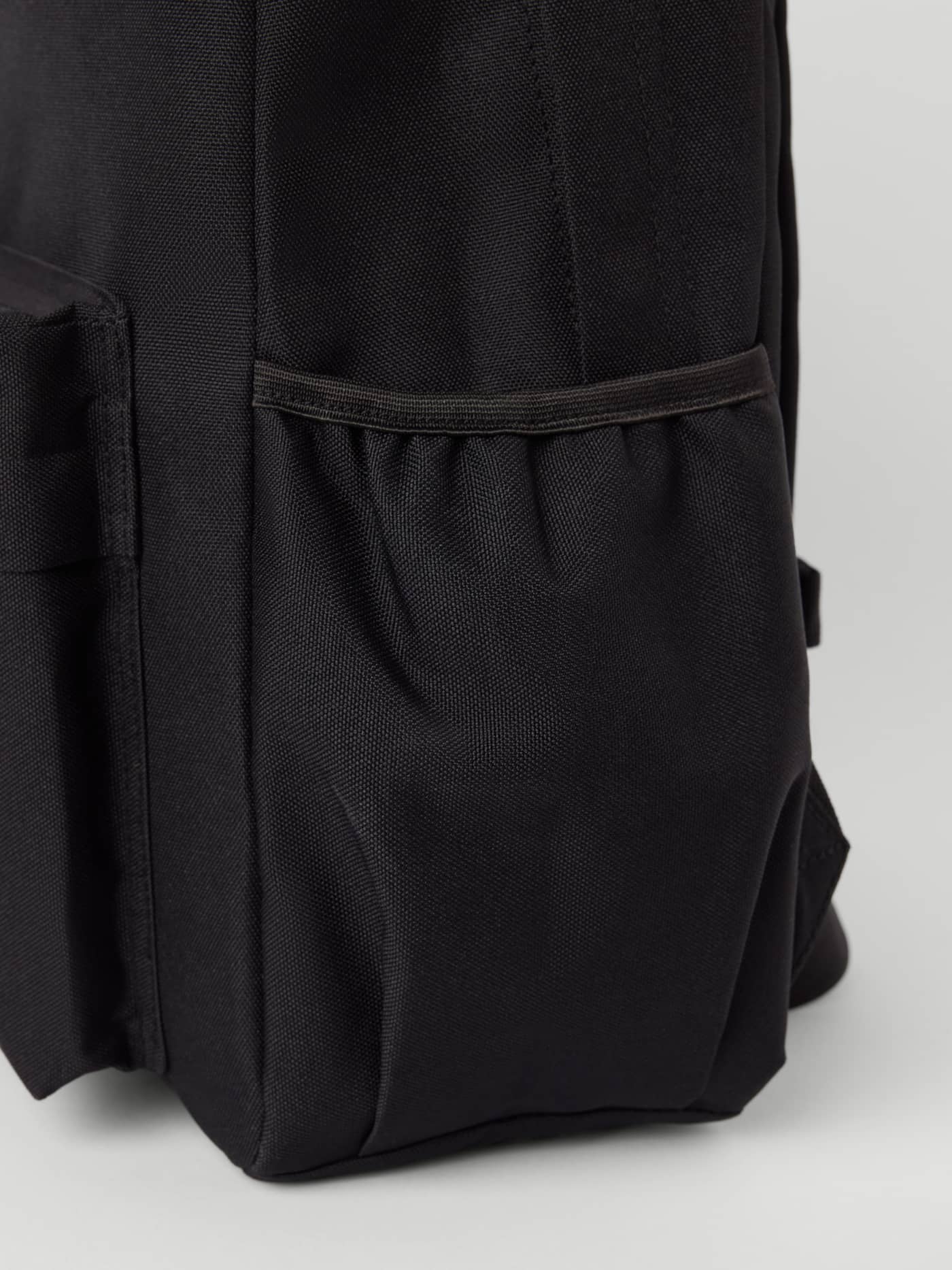 Tæt på den stilfulde Borg Kids Backpack 15L i Black Beauty (Sort) med en slidstærk sidelomme af polyester. - Image 3
