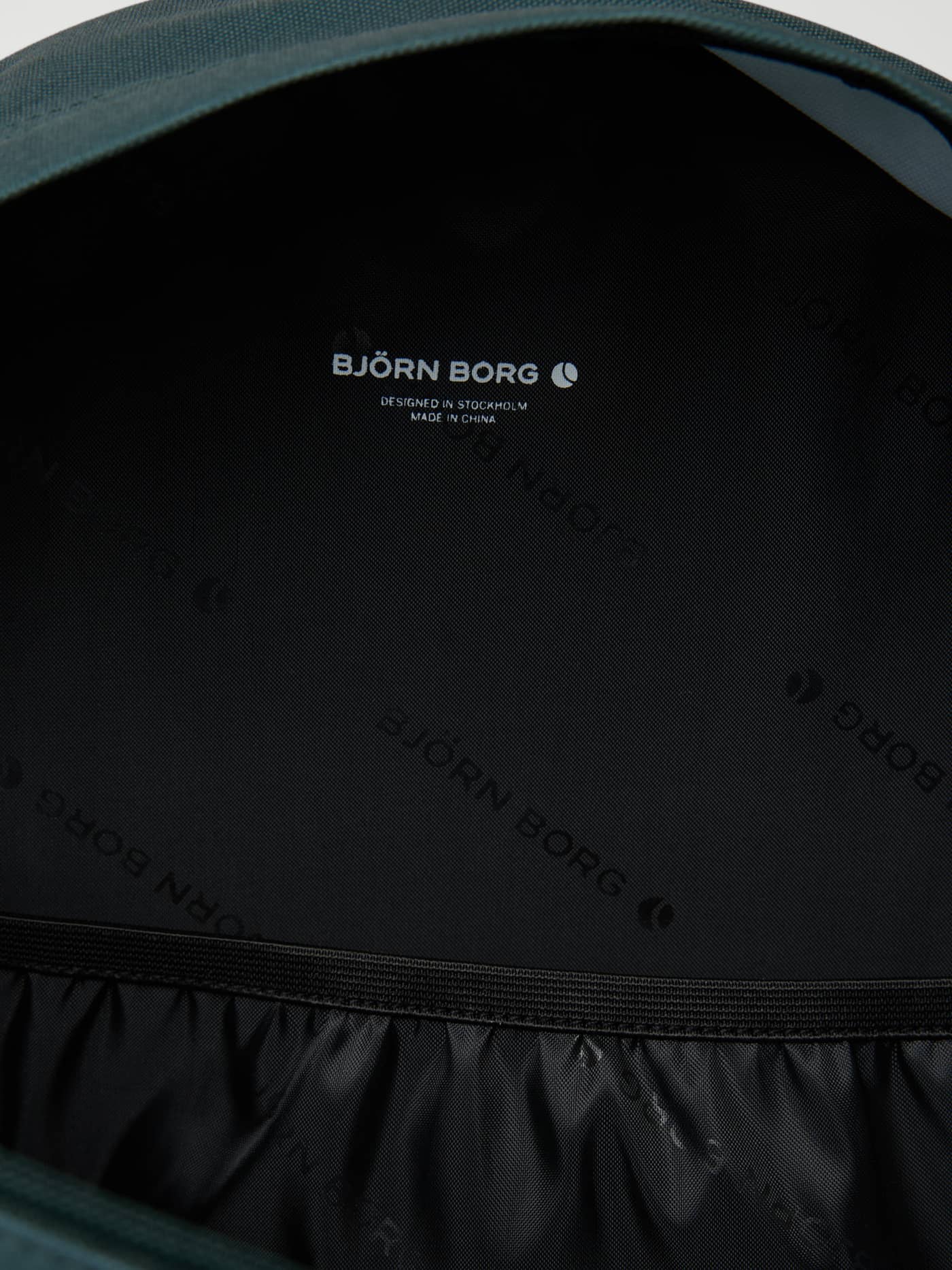 Borg Kids Backpack 15L in Mallard Green (Green) interior with a black logo print lining and white logo. - Image 3